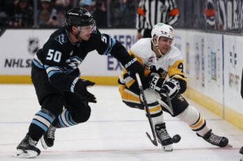 Mar 14, 2026; Salt Lake City, Utah, USA; Utah Mammoth defenseman Sean Durzi (50) and Pittsburgh Penguins center Blake Lizotte (46) battle for the puck during the third period at Delta Center. Mandatory Credit: Rob Gray-Imagn Images