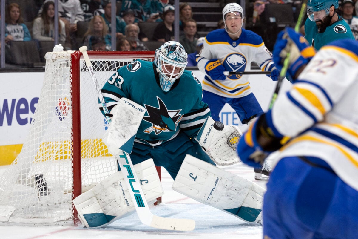 Mar 19, 2026; San Jose, California, USA; San Jose Sharks goaltender Alex Nedelijkovic (33) deflects a shot on goal by Buffalo Sabres right wing Jack Quinn (22) during the first period at SAP Center at San Jose. Mandatory Credit: D. Ross Cameron-Imagn Images