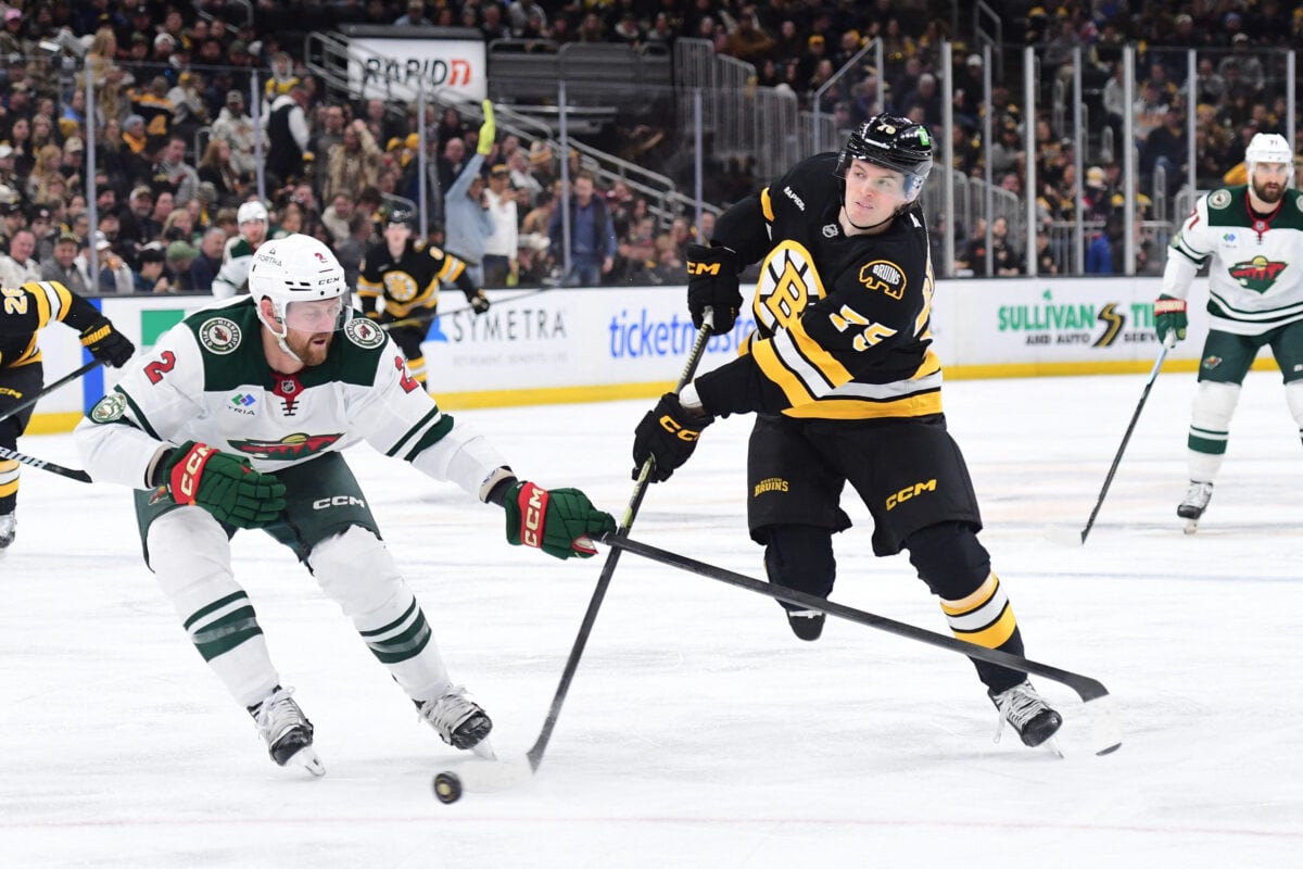 Mar 28, 2026; Boston, Massachusetts, USA; Boston Bruins forward Lukas Reichel shoots the puck while Minnesota Wild defenseman Jeff Petry (2) defends during the third period at TD Garden. Mandatory Credit: Bob DeChiara-Imagn Images