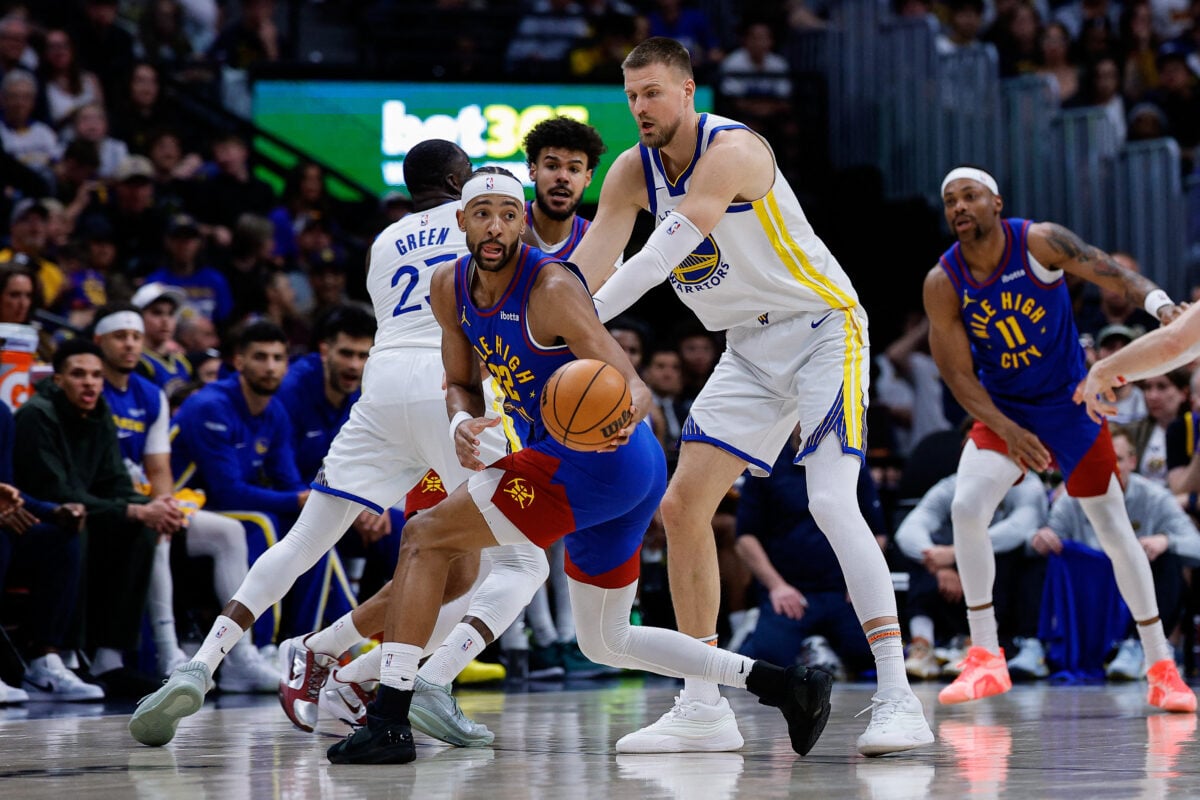 Mar 29, 2026; Denver, Colorado, USA; Denver Nuggets forward Zeke Nnaji (22) controls the ball under pressure from Golden State Warriors center Kristaps Porzingis (7) in the second quarter at Ball Arena. Mandatory Credit: Isaiah J. Downing-Imagn Images