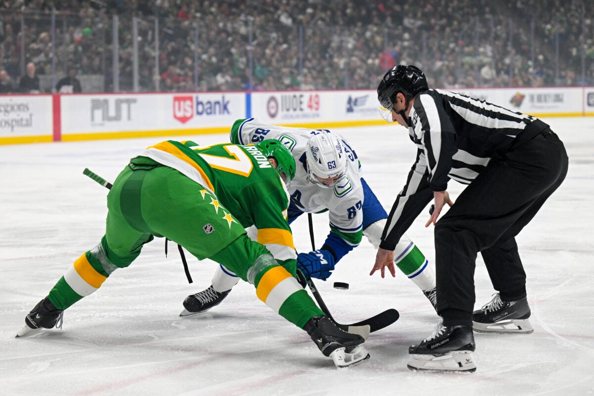 Apr 2, 2026; Saint Paul, Minnesota, USA;  Minnesota Wild forward Micael McCarron (47) and Vancouver Canucks forward Max Sasson (63) face-off during the first period at Grand Casino Arena. Mandatory Credit: Nick Wosika-Imagn Images