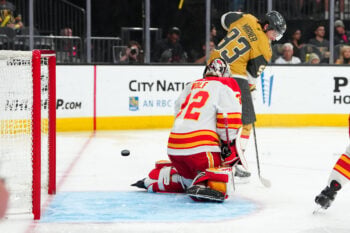 Apr 2, 2026; Las Vegas, Nevada, USA; Vegas Golden Knights right wing Mitch Marner (93) deflects the puck past Calgary Flames goaltender Dustin Wolf (32) to score a goal during the second period at T-Mobile Arena. Mandatory Credit: Stephen R. Sylvanie-Imagn Images