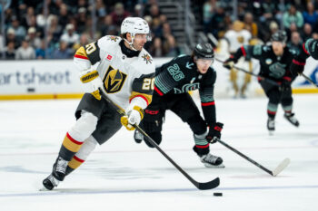 Apr 9, 2026; Seattle, Washington, USA;  Vegas Golden Knights forward Brandon Saad (20) skates with the puck against Seattle Kraken forward Ryan Winterton (26) at Climate Pledge Arena. Mandatory Credit: Stephen Brashear-Imagn Images