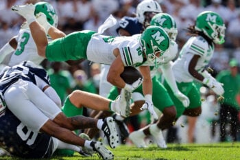 Sep 5, 2026; University Park, Pennsylvania, USA;  Marshall Thundering Herd running back Judah Price (10) leaps forward with the ball on a punt return during the first quarter against the Penn State Nittany Lions at West Shore Home Field at Beaver Stadium.  Mandatory Credit: Matthew O'Haren-Imagn Images