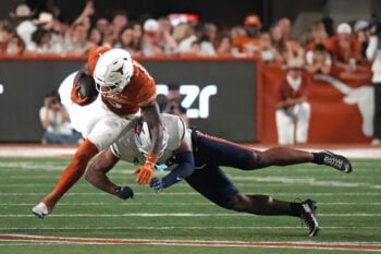 Sep 19, 2026; Austin, Texas, USA;  Texas Longhorns running back Derrek Cooper (5) runs for yardage while defended by UTSA Roadrunners linebacker James Walley Jr. (34) during the second half at Darrell K Royal-Texas Memorial Stadium.  Mandatory Credit: Scott Wachter-Imagn Images