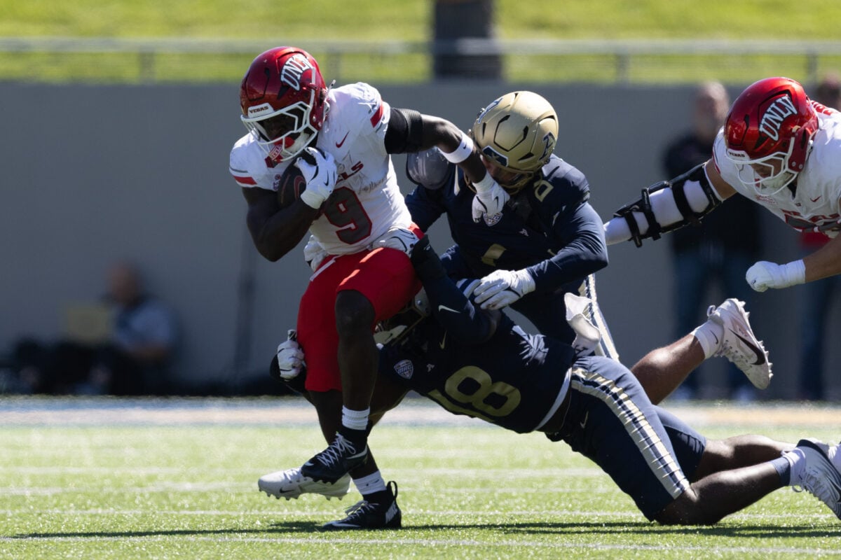 UNLV running back Jai'Den Thomas (9) runs through two Akron defenders Sept. 26, 2026, at InfoCision Stadium in Akron.