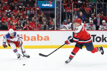 Oct 9, 2026; Washington, District of Columbia, USA; Washington Capitals defenseman Jakob Chychrun (6) shoots the puck as New York Rangers center Noah Laba (42) defends during the first period at Capital One Arena. Mandatory Credit: Geoff Burke-Imagn Images
