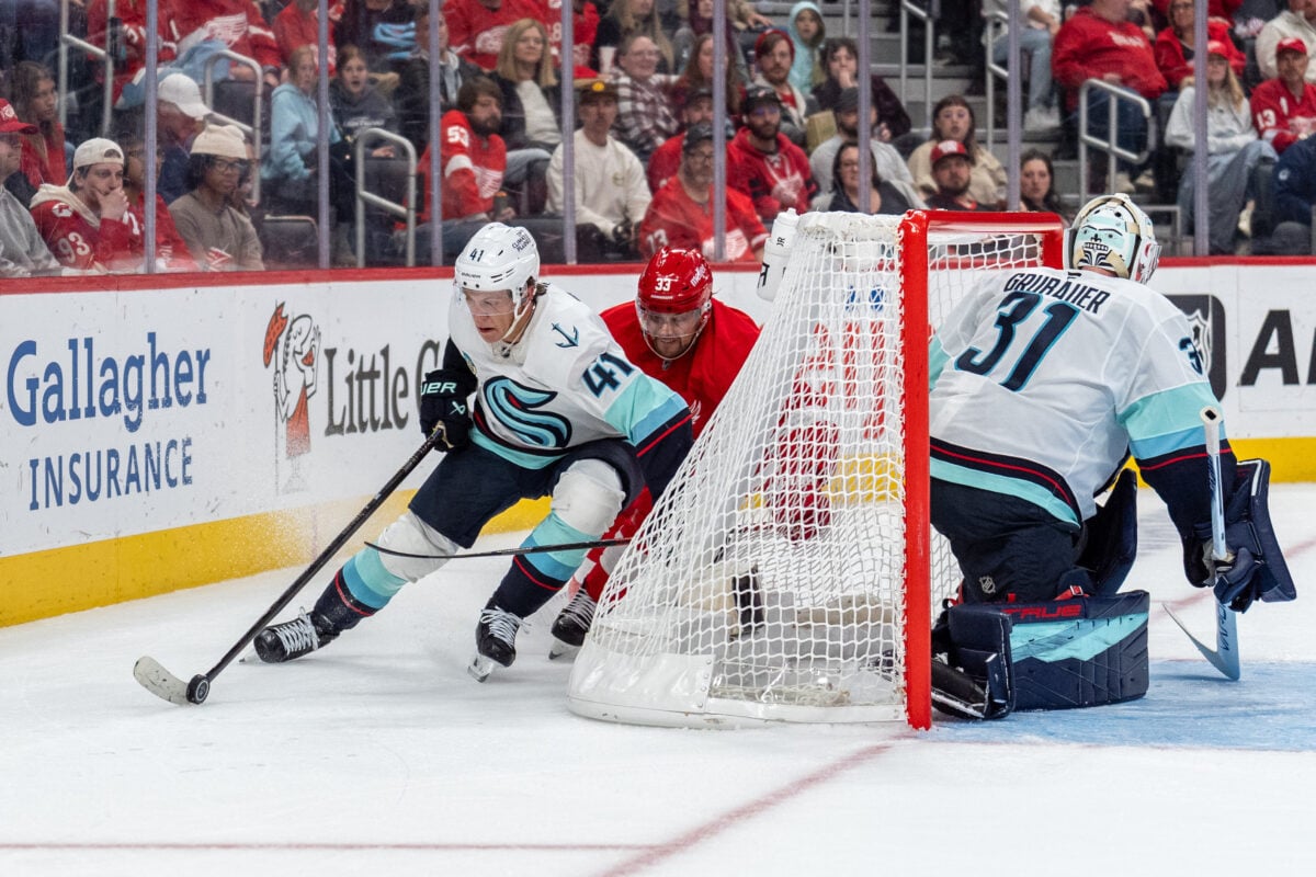 Oct 9, 2026; Detroit, Michigan, USA; Seattle Kraken defenseman Ryker Evans (41) carries the puck behind his own net while pressured by Detroit Red Wings left wing Viktor Arvidsson (33) in the second period at Little Caesars Arena. Mandatory Credit: Paul Barnick-Imagn Images