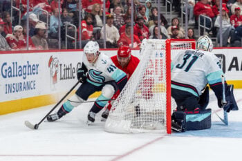 Oct 9, 2026; Detroit, Michigan, USA; Seattle Kraken defenseman Ryker Evans (41) carries the puck behind his own net while pressured by Detroit Red Wings left wing Viktor Arvidsson (33) in the second period at Little Caesars Arena. Mandatory Credit: Paul Barnick-Imagn Images