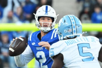 Oct 17, 2026; Durham, North Carolina, USA;  Duke Blue Devils quarter back Walker Eget (2) looks for a pass against North Carolina Tar Heels defensive lineman Donovan Hoilette Jr. (5) during the third quarter at Wallace Wade Stadium.  Mandatory Credit: Zachary Taft-Imagn Images
