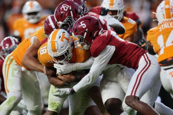 Oct 17, 2026; Knoxville, Tennessee, USA;  Alabama Crimson Tide linebacker Jah-Marien Latham (20) and defensive back Dijon Lee Jr. (5) tackle Tennessee Volunteers running back DeSean Bishop (18) during the second half at Neyland Stadium.  Mandatory Credit: Randy Sartin-Imagn Images
