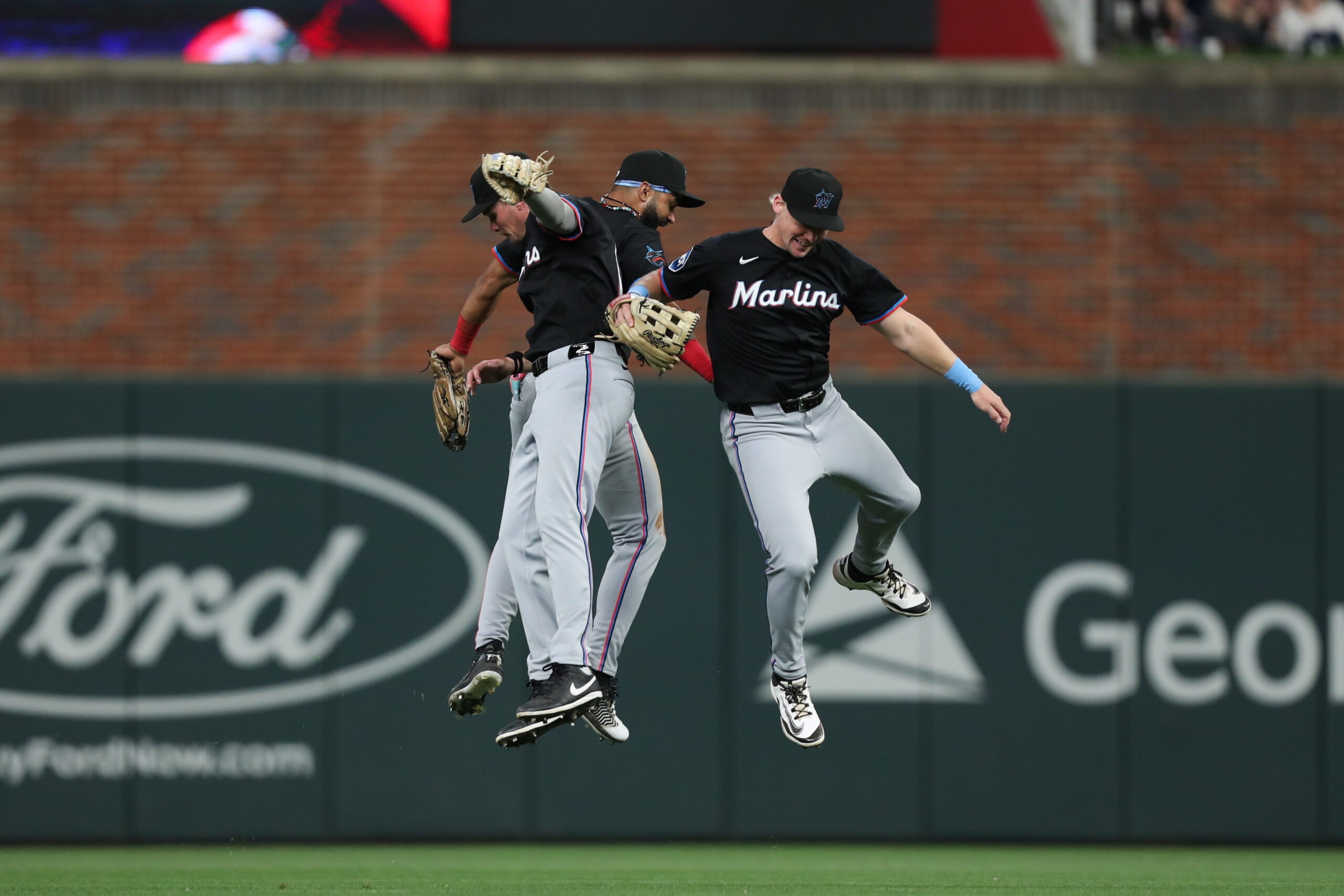 Apr 5, 2025; Cumberland, Georgia, USA; Miami Marlins outfielder Kyle Stowers (28), Miami Marlins outfielder Griffin Conine (18) and Miami Marlins outfielder Derek Hill (3) celebrate the win against the Atlanta Braves at Truist Park. Mandatory Credit: Mady Mertens-Imagn Images