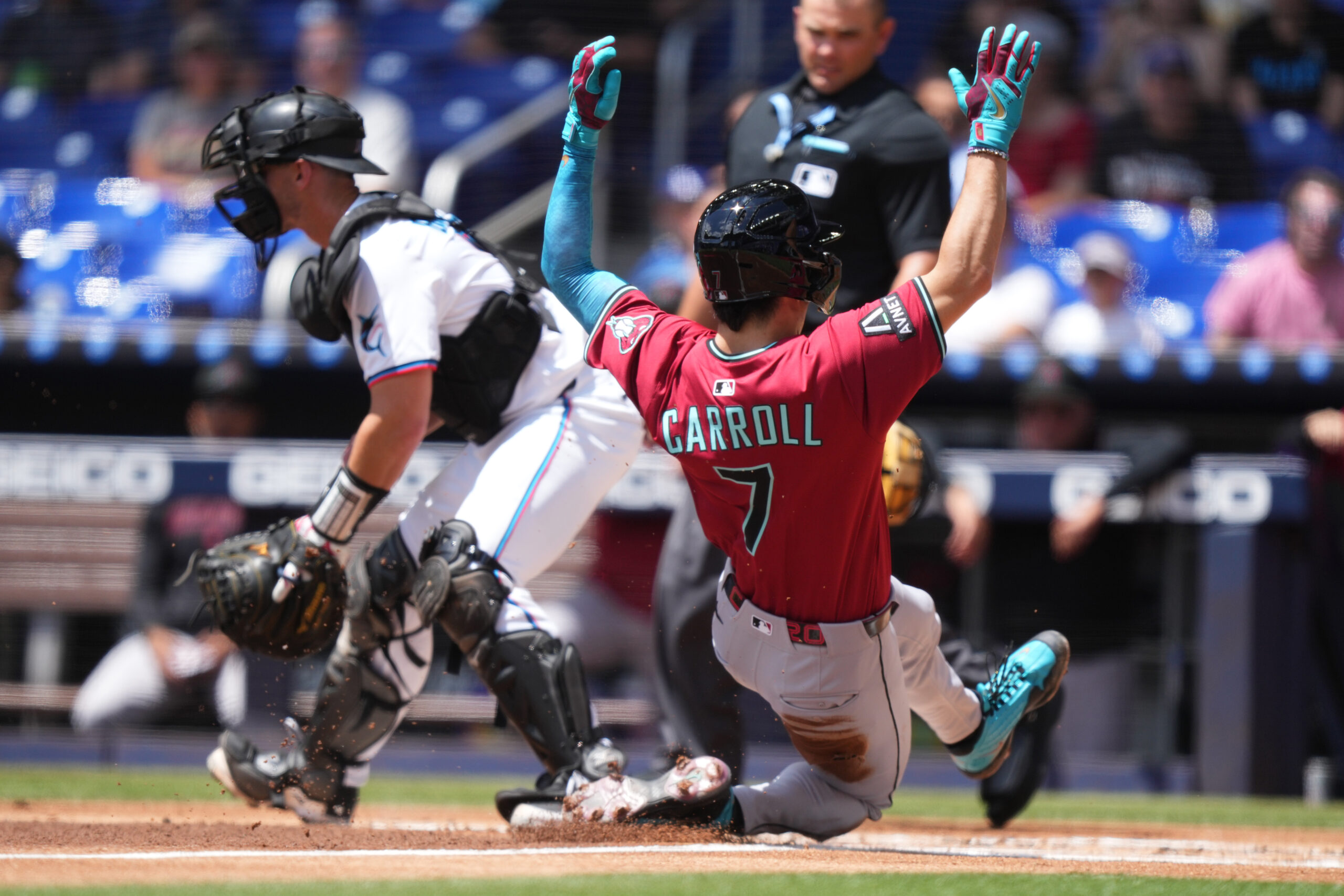 Apr 17, 2025; Miami, Florida, USA;  Arizona Diamondbacks right fielder Corbin Carroll (7) scores a run as Miami Marlins catcher Rob Brantly (19) looks on at loanDepot Park. Mandatory Credit: Jim Rassol-Imagn Images