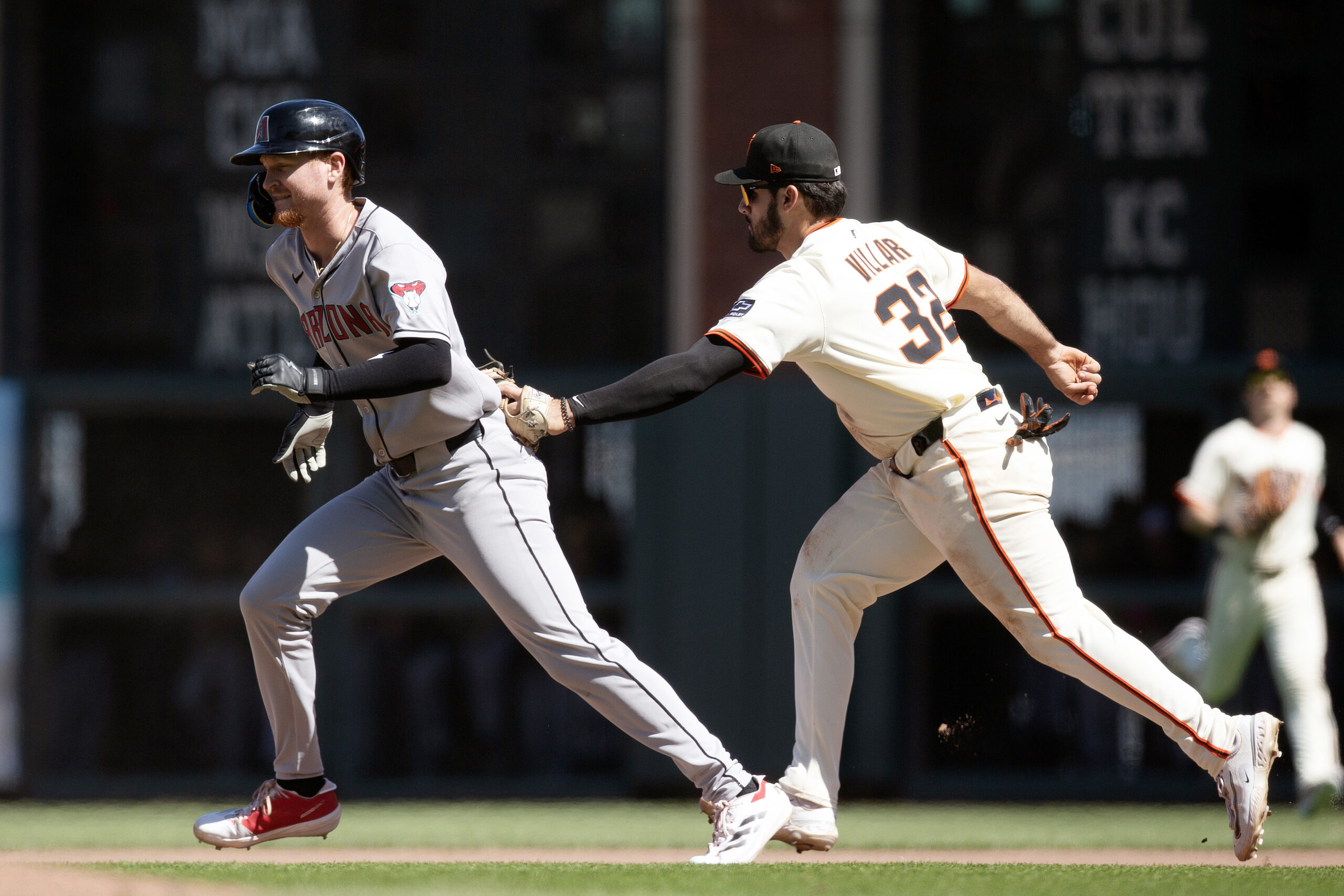 May 14, 2025; San Francisco, California, USA; San Francisco Giants first baseman David Villar (32) tags Arizona Diamondbacks first baseman Pavin Smith (26) after he was caught in a rundown between first and second base during the ninth inning at Oracle Park. Mandatory Credit: D. Ross Cameron-Imagn Images