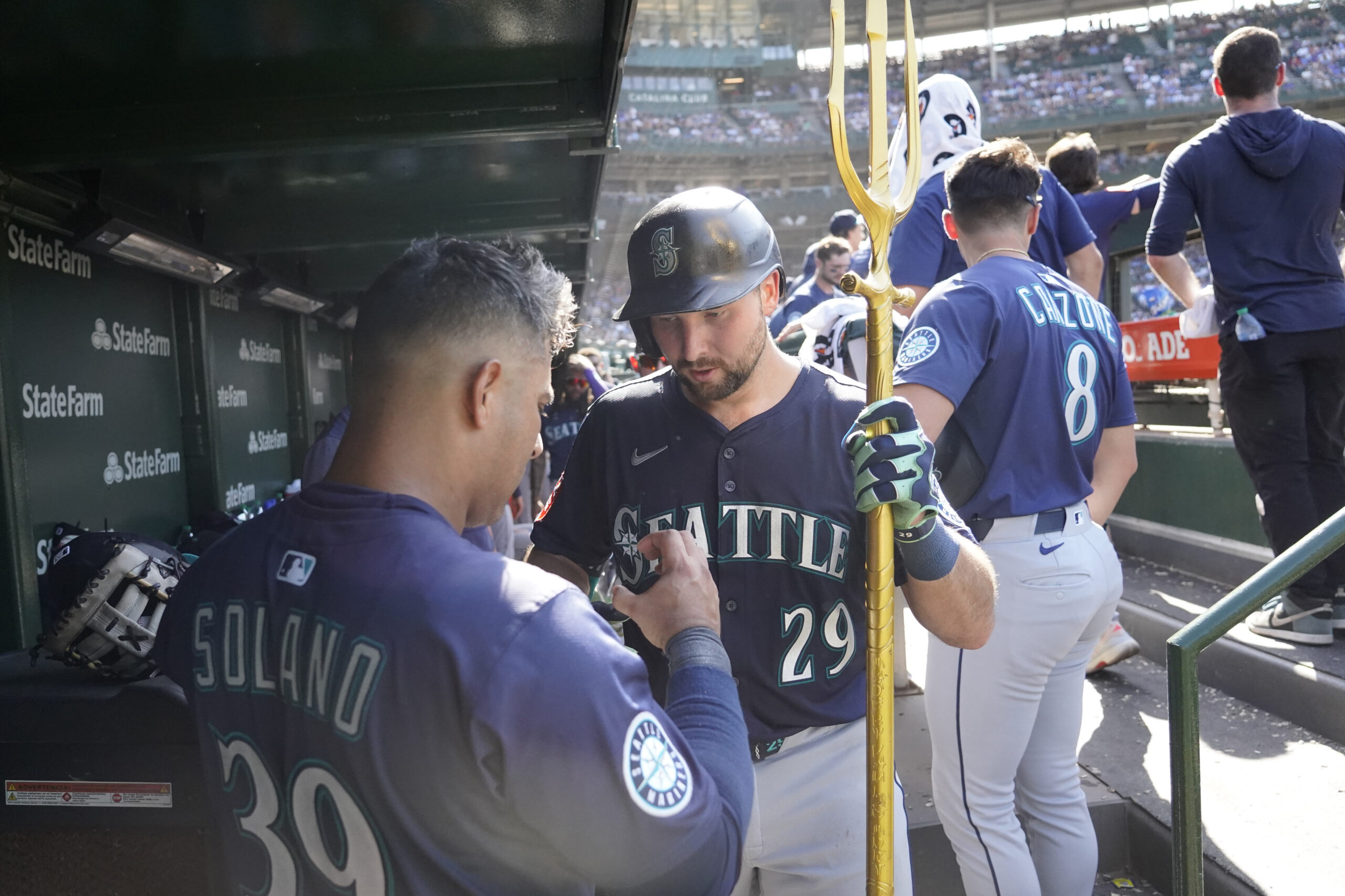 Jun 21, 2025; Chicago, Illinois, USA; Seattle Mariners catcher Cal Raleigh (29) is greeted in the dugout after hitting a home run against the Chicago Cubs during the ninth inning at Wrigley Field. Mandatory Credit: David Banks-Imagn Images