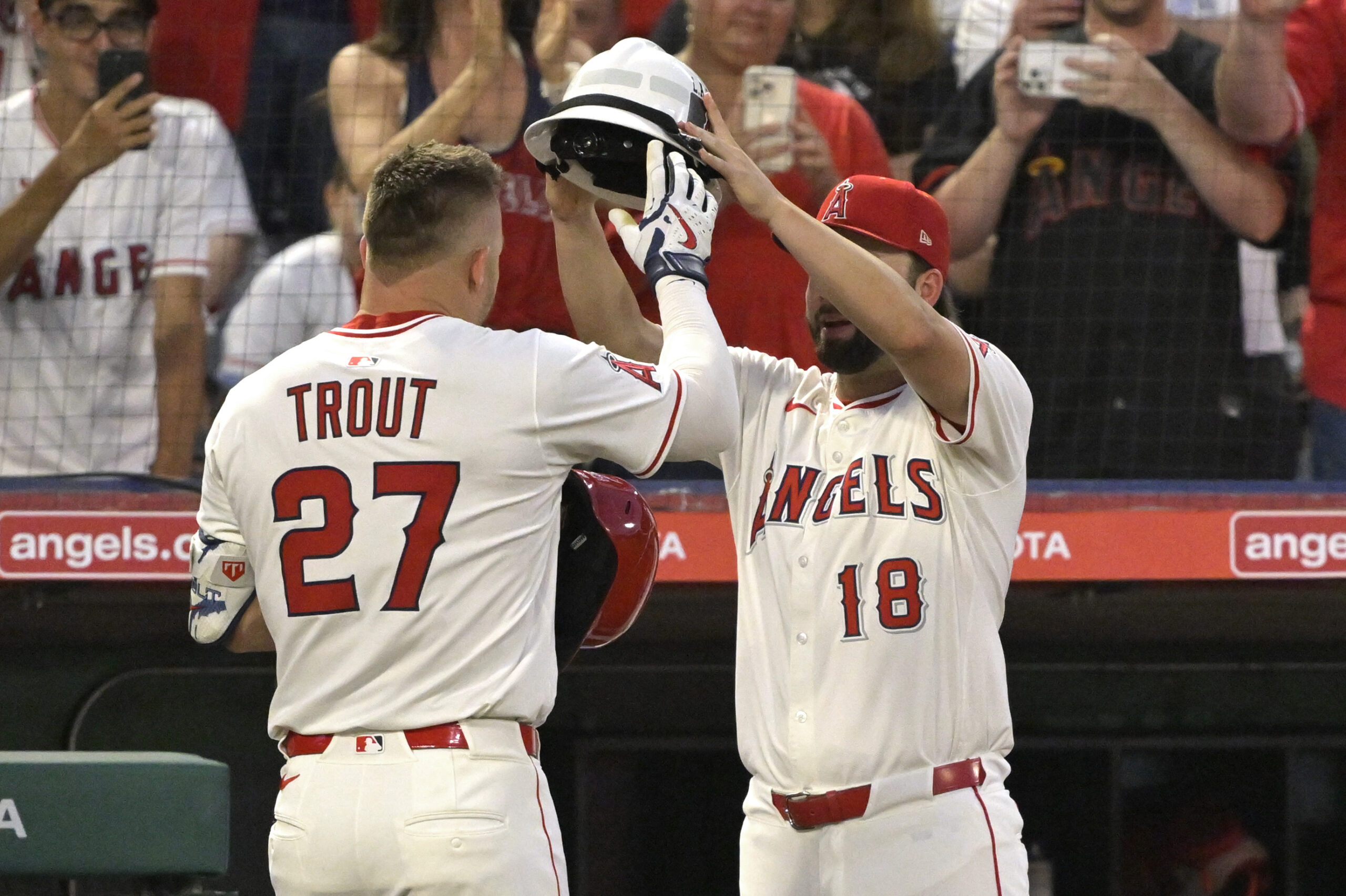 Jun 28, 2025; Anaheim, California, USA;  Los Angeles Angels right fielder Mike Trout (27) is is greeted at the dugout by first baseman Nolan Schanuel (18) after hitting a solo home run in the seventh inning against the Washington Nationals at Angel Stadium. Mandatory Credit: Jayne Kamin-Oncea-Imagn Images