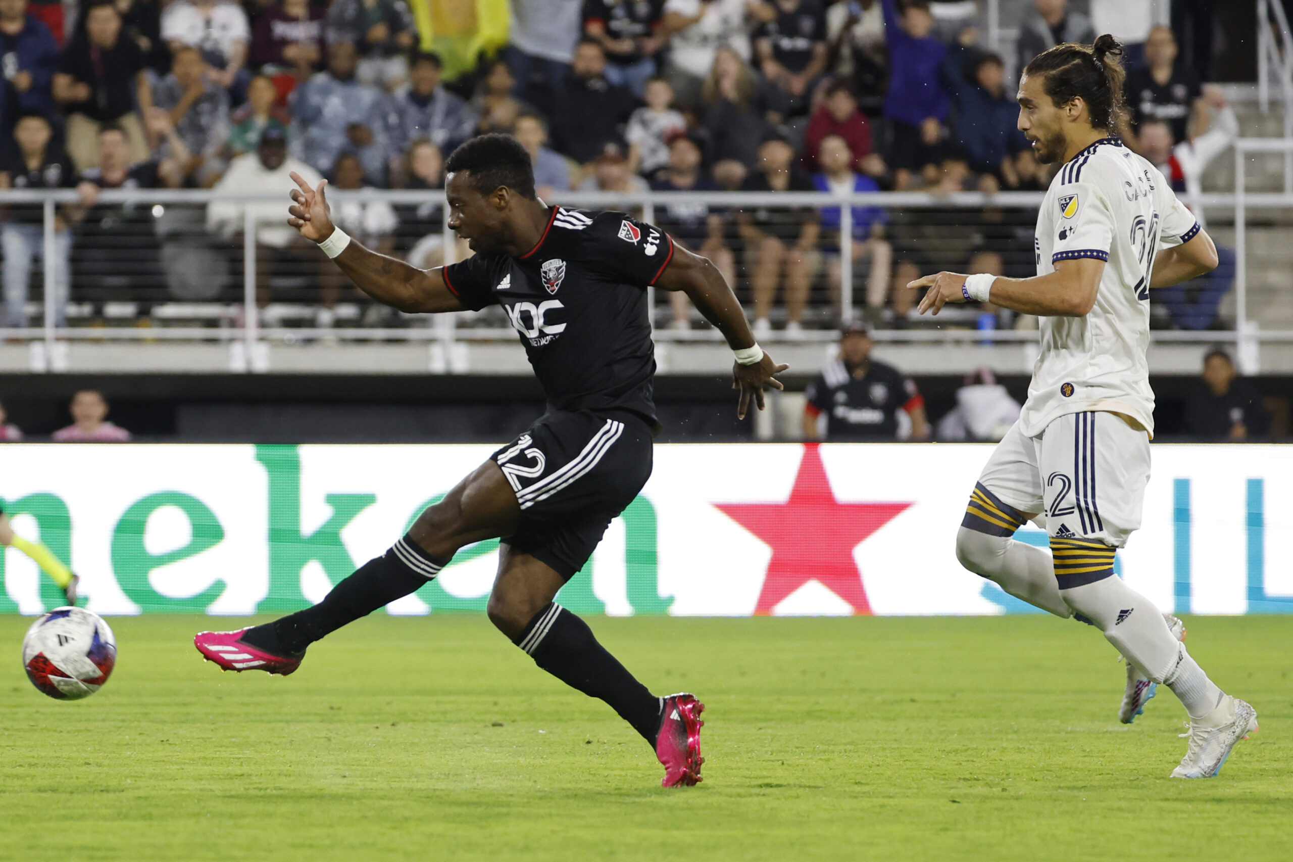 May 20, 2023; Washington, District of Columbia, USA; D.C. United forward Cristi n D jome (12)  scores a goal as LA Galaxy defender Mart n C ceres (22) looks on in the second half at Audi Field. Mandatory Credit: Geoff Burke-Imagn Images