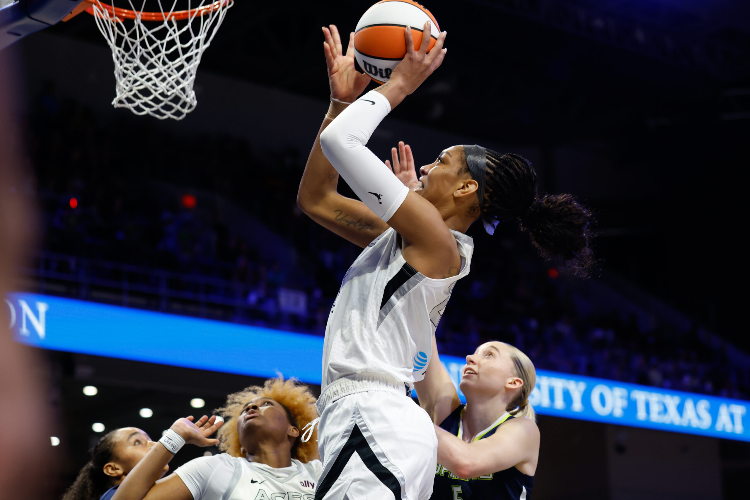 Jul 16, 2025; Arlington, Texas, USA;Las Vegas Aces center A'ja Wilson (22) scores a layup past Dallas Wings guard Paige Bueckers (5)  during the first half at College Park Center. Mandatory Credit: Chris Jones-Imagn Images
