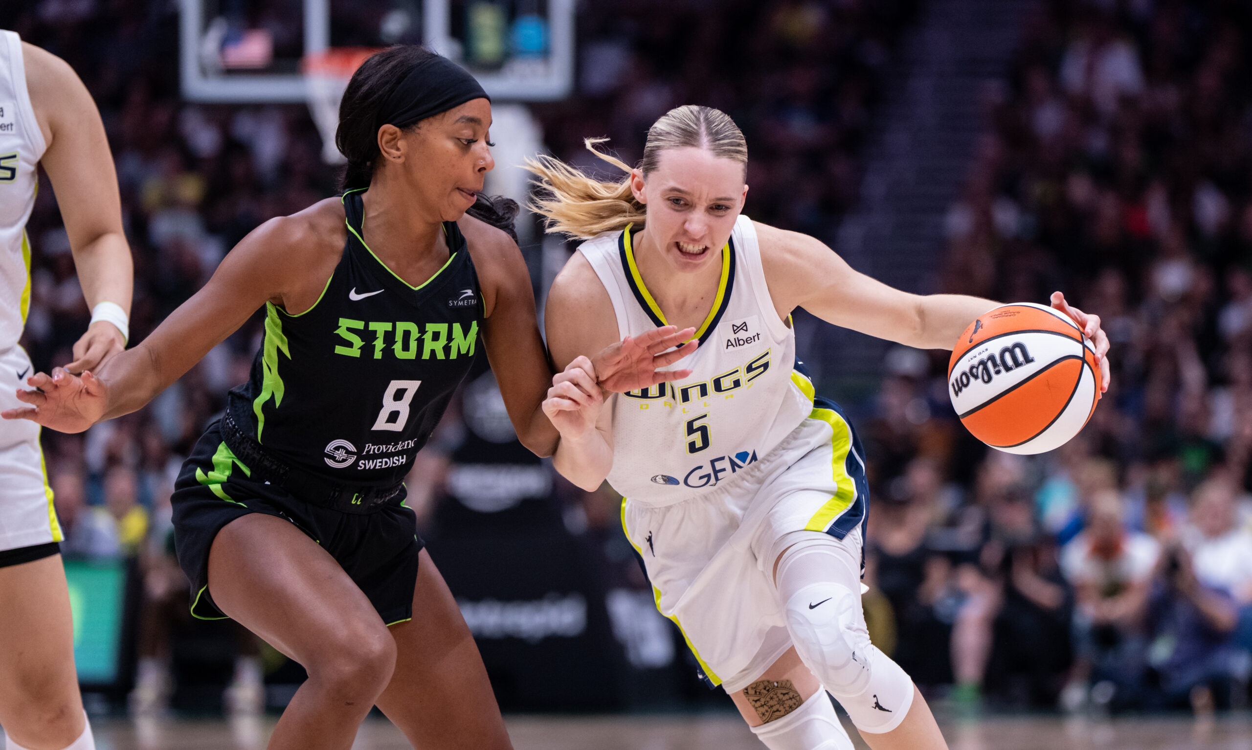 Jul 22, 2025; Seattle, Washington, USA;  Dallas Wings guard Paige Bueckers (5) dribbles the ball against Seattle Storm guard Lexie Brown (8) during the second half at Climate Pledge Arena. Mandatory Credit: Stephen Brashear-Imagn Images