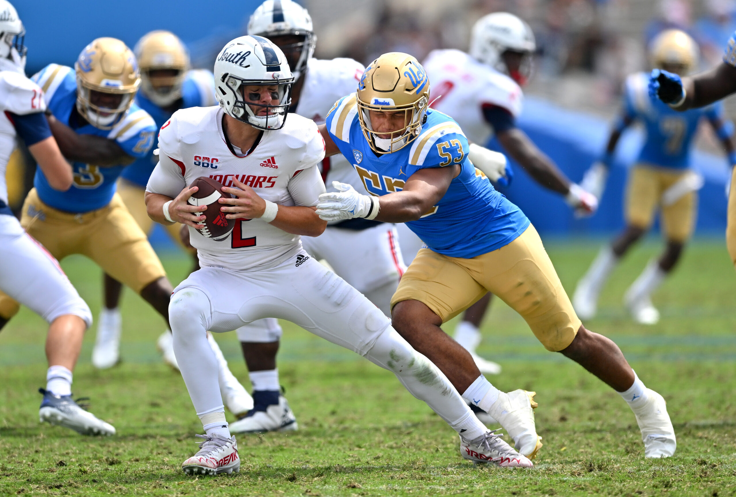 Sep 17, 2022; Pasadena, California, USA;  South Alabama Jaguars quarterback Carter Bradley (2) escapes a sack by UCLA Bruins linebacker Darius Muasau (53) in the second half against the UCLA Bruins at the Rose Bowl. Mandatory Credit: Jayne Kamin-Oncea-Imagn Images