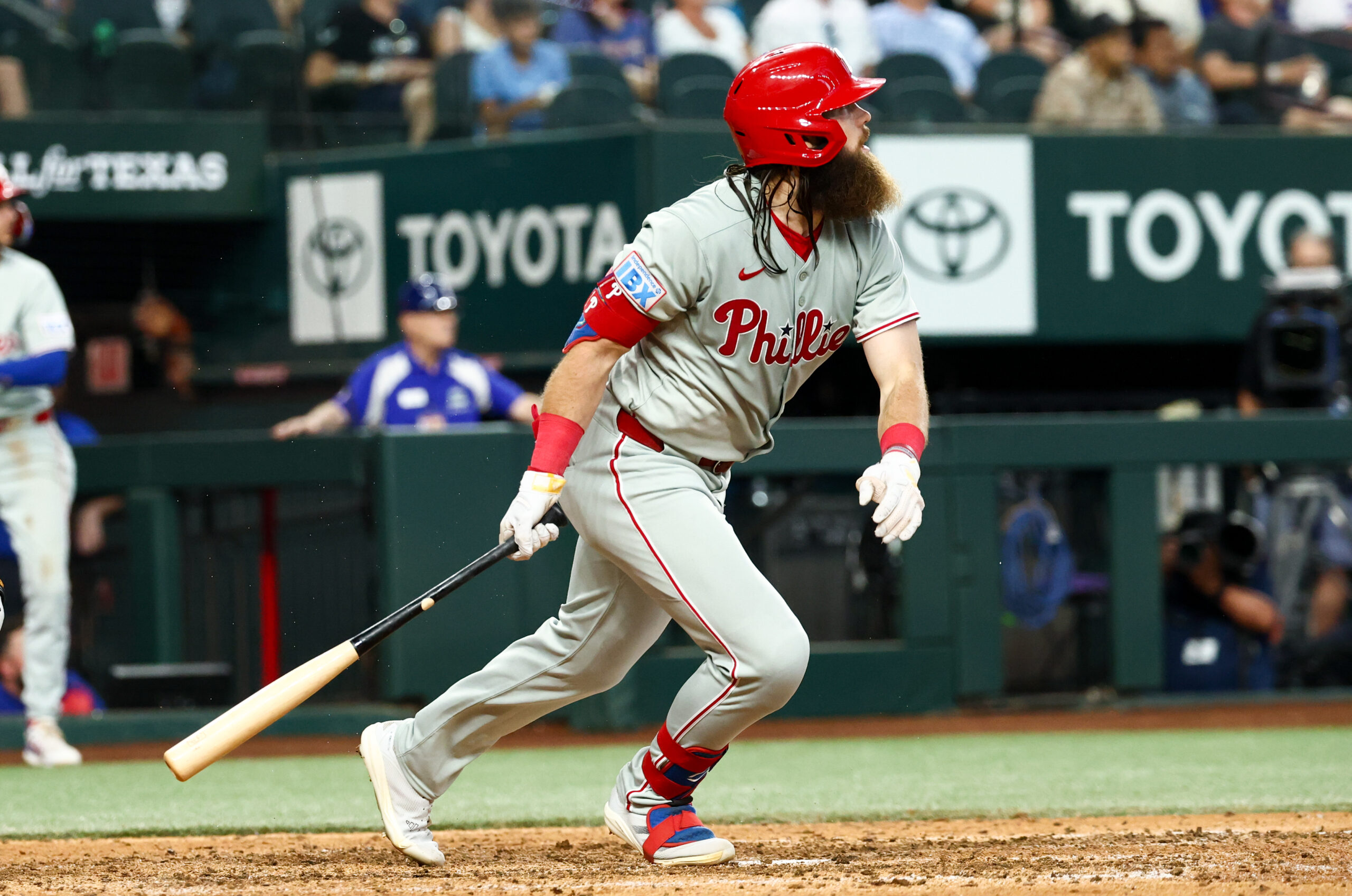Aug 10, 2025; Arlington, Texas, USA; Philadelphia Phillies center fielder Brandon Marsh (16) hits an rbi sacrifice fly  during the ninth inning against the Texas Rangers at Globe Life Field. Mandatory Credit: Kevin Jairaj-Imagn Images