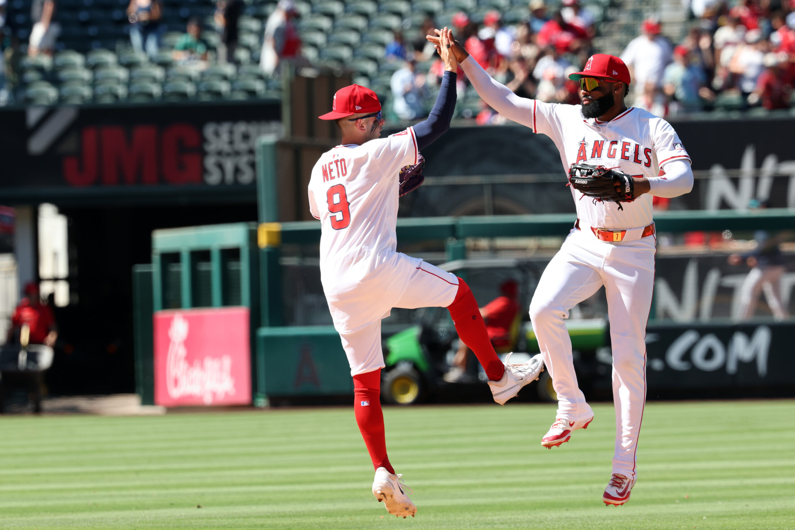 Jul 27, 2025; Anaheim, California, USA;  Los Angeles Angels shortstop Zach Neto (9) and center fielder Jo Adell (7) celebrate a win after defeating the Seattle Mariners 4-1 at Angel Stadium. Mandatory Credit: Kiyoshi Mio-Imagn Images