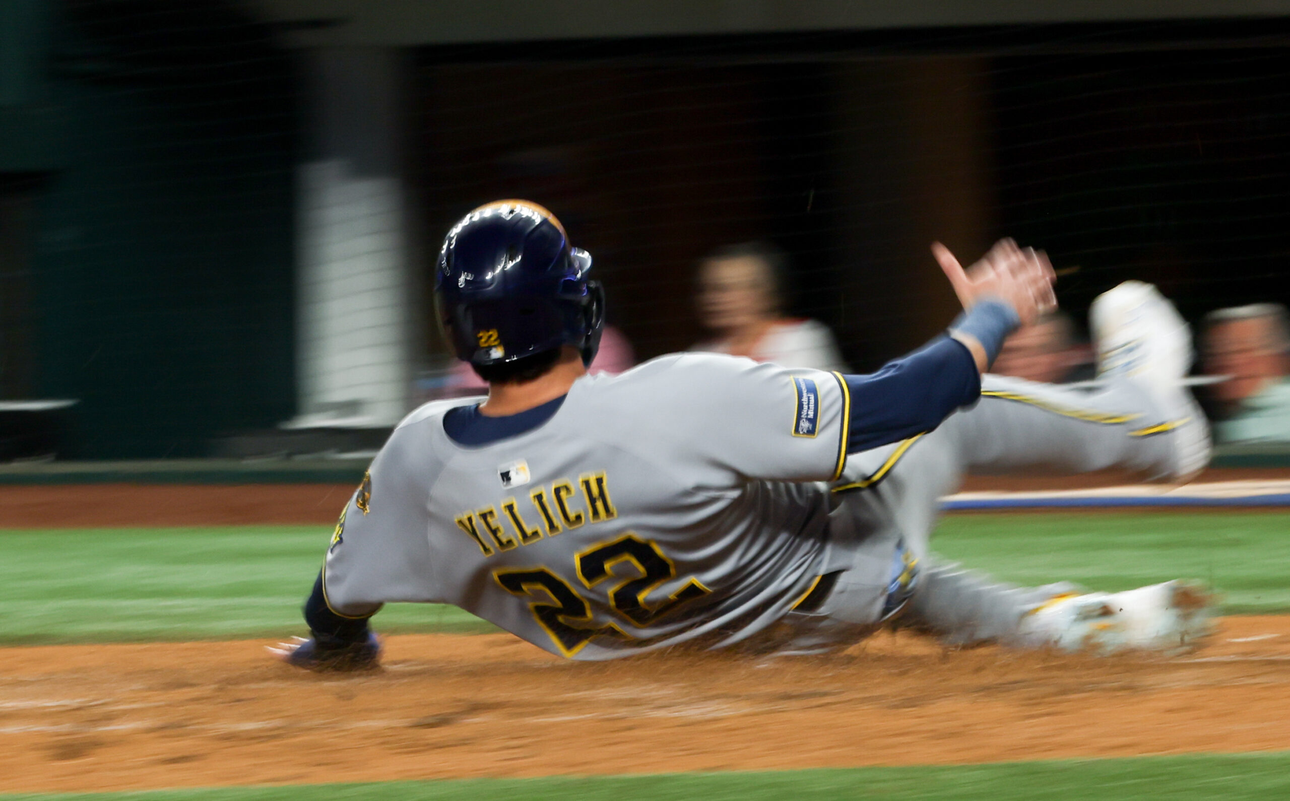 Sep 9, 2025; Arlington, Texas, USA; (Editor's note: Slow shutter image.) Milwaukee Brewers designated hitter Christian Yelich (22) scores during the fifth inning against the Texas Rangers at Globe Life Field. Mandatory Credit: Kevin Jairaj-Imagn Images
