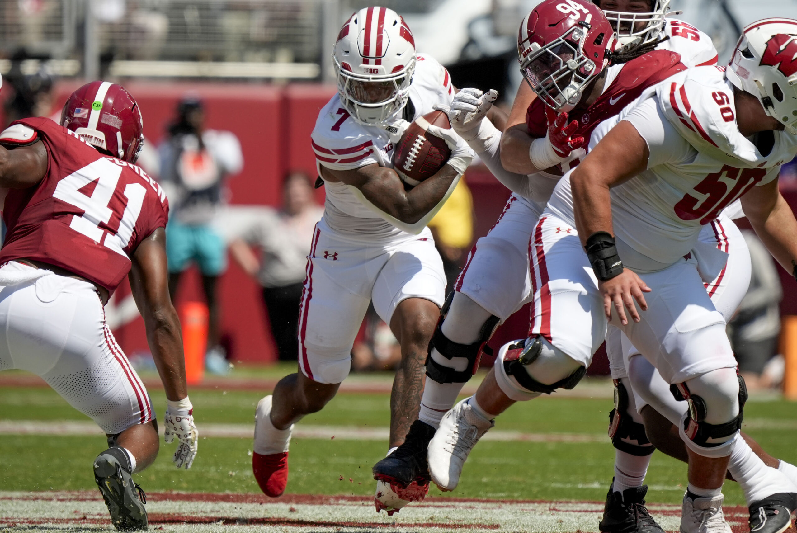 Sep 13, 2025; Tuscaloosa, Alabama, USA; Wisconsin running back Dilin Jones (7) runs the ball between Alabama linebacker Nikhai Hill-Green (41) and Alabama defensive lineman Edric Hill (94) at Saban Field at Bryant-Denny Stadium. Mandatory Credit: Gary Cosby-USA TODAY Network via Imagn Images