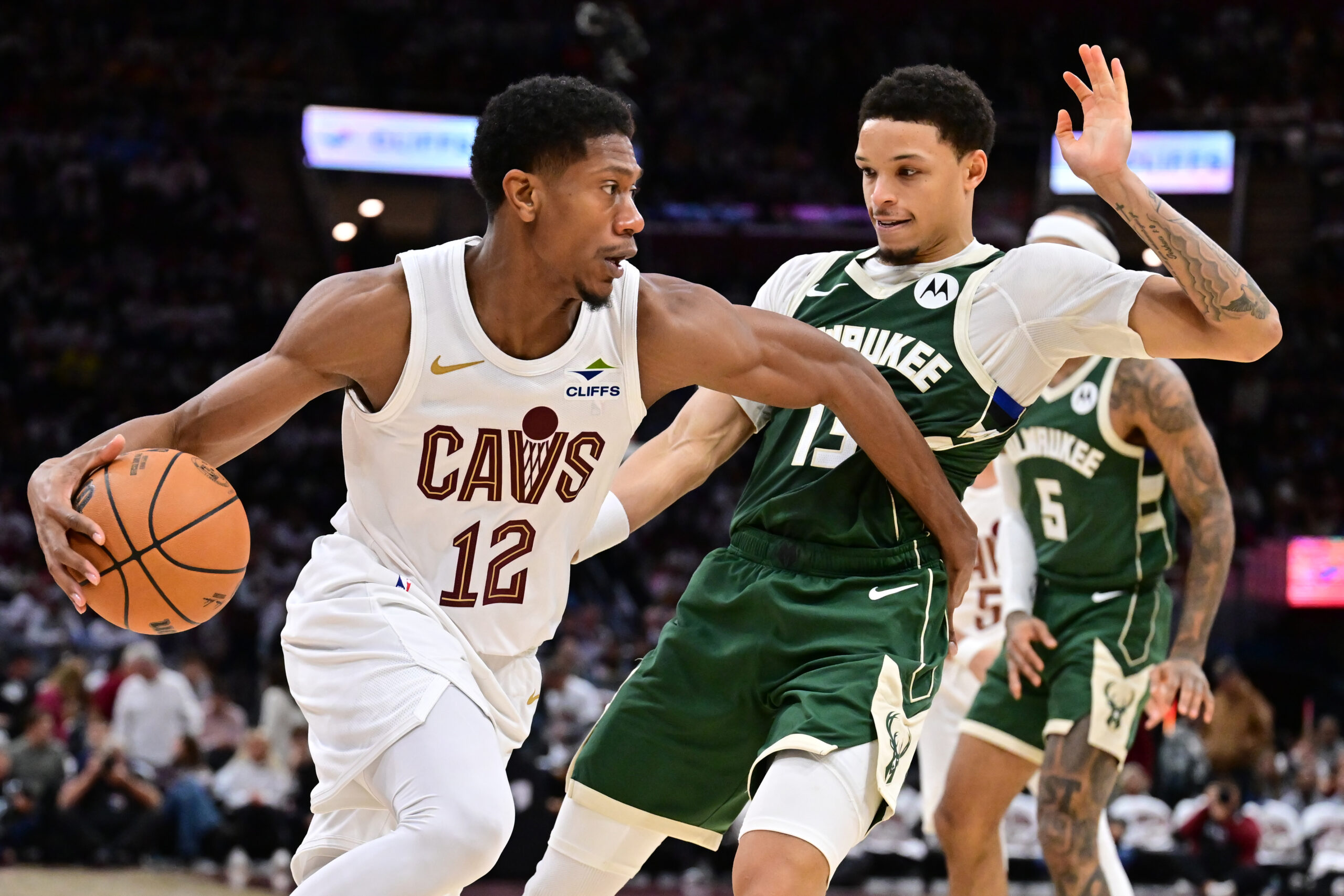 Oct 26, 2025; Cleveland, Ohio, USA; Cleveland Cavaliers guard De'Andre Hunter (12) drives to the basket against Milwaukee Bucks guard Ryan Rollins (13) during the second half at Rocket Arena. Mandatory Credit: Ken Blaze-Imagn Images