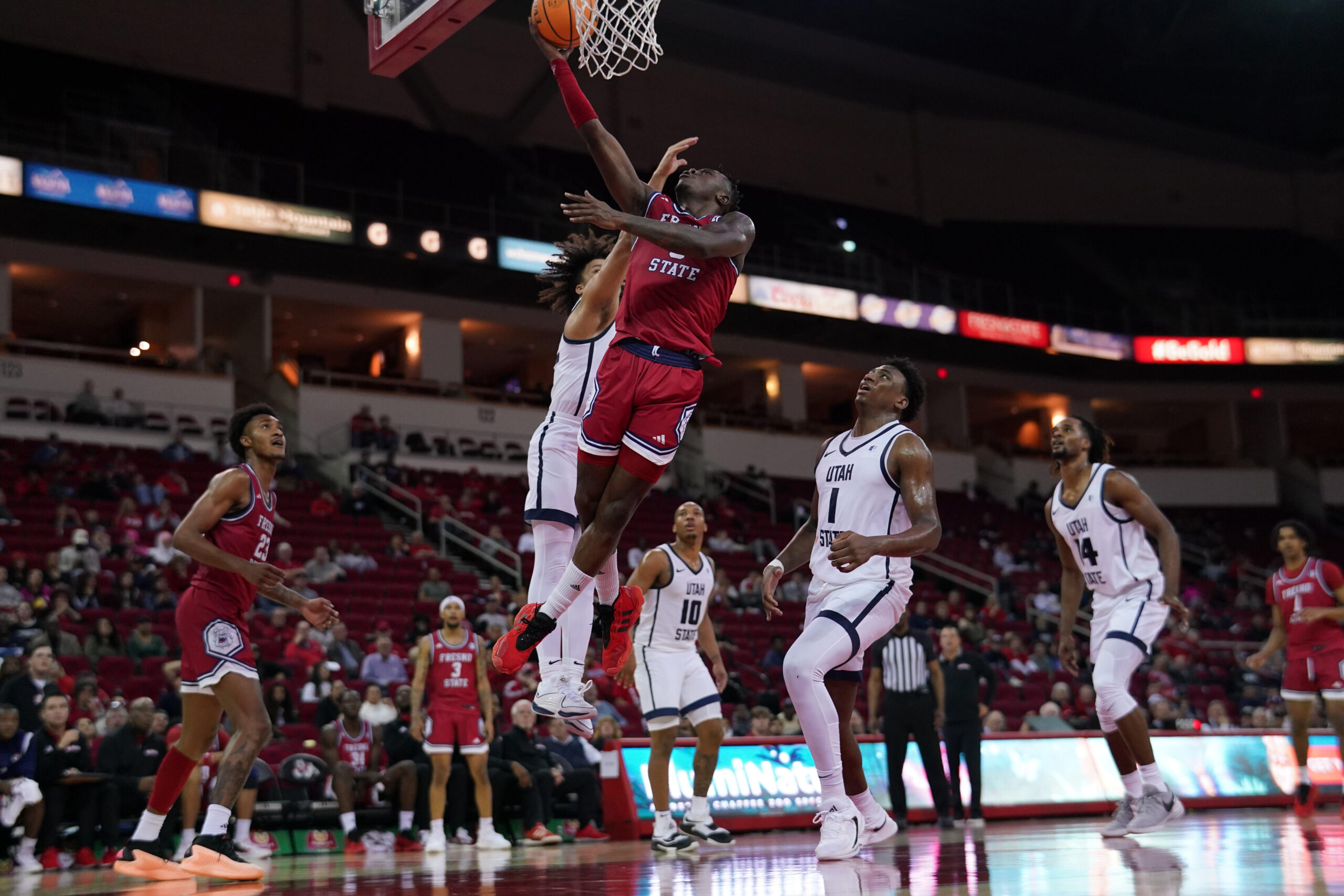 Feb 27, 2024; Fresno, California, USA; Fresno State Bulldogs guard Jalen Weaver (5) makes a layup in front of Utah State Aggies guard Javon Jackson (22) in the second half at the Save Mart Center. Mandatory Credit: Cary Edmondson-Imagn Images