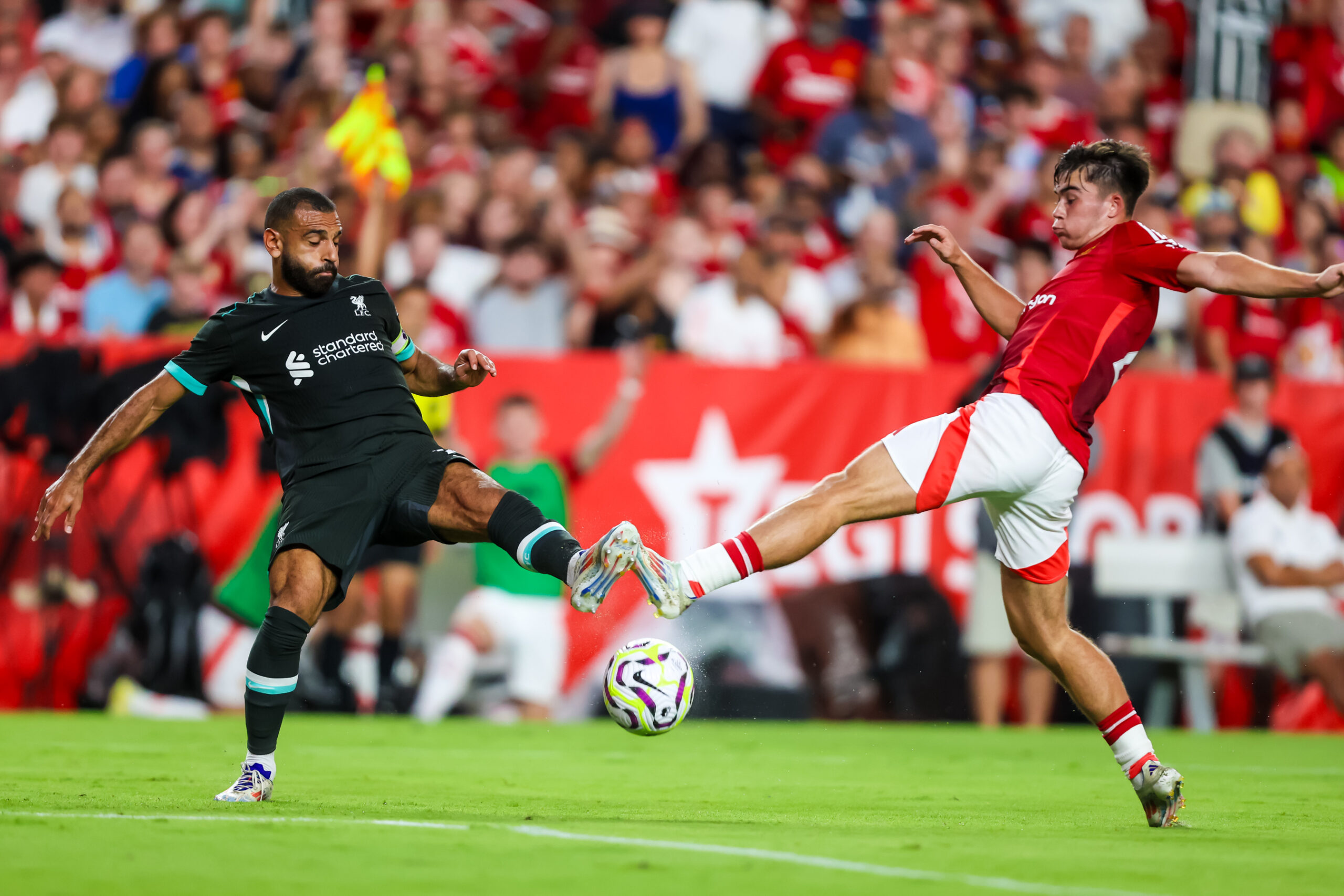 Aug 3, 2024; Columbia, South Carolina, USA;  Liverpool forward Mohamed Salah (11) and Manchester United defender Harry Amass (41) battle for the ball at Williams-Brice Stadium. Mandatory Credit: Jeff Blake-Imagn Images