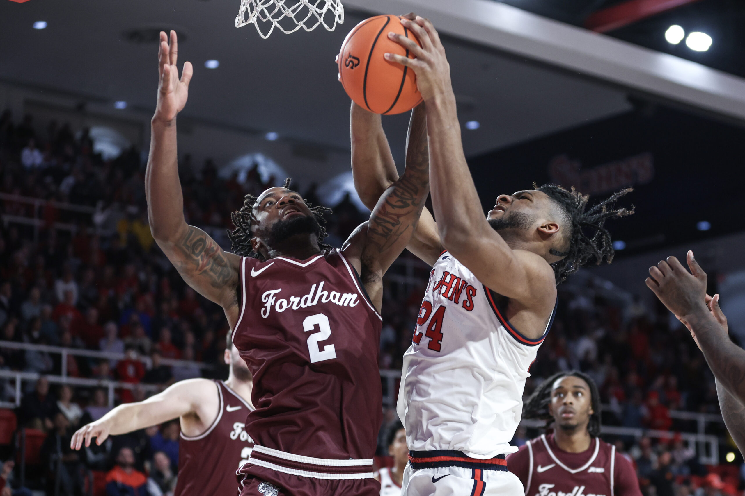Nov 4, 2024; Queens, New York, USA;  Fordham Rams forward Romad Dean (2) and St. John's Red Storm forward Zuby Ejiofor (24) fight for a rebound in the second half at Carnesecca Arena. Mandatory Credit: Wendell Cruz-Imagn Images