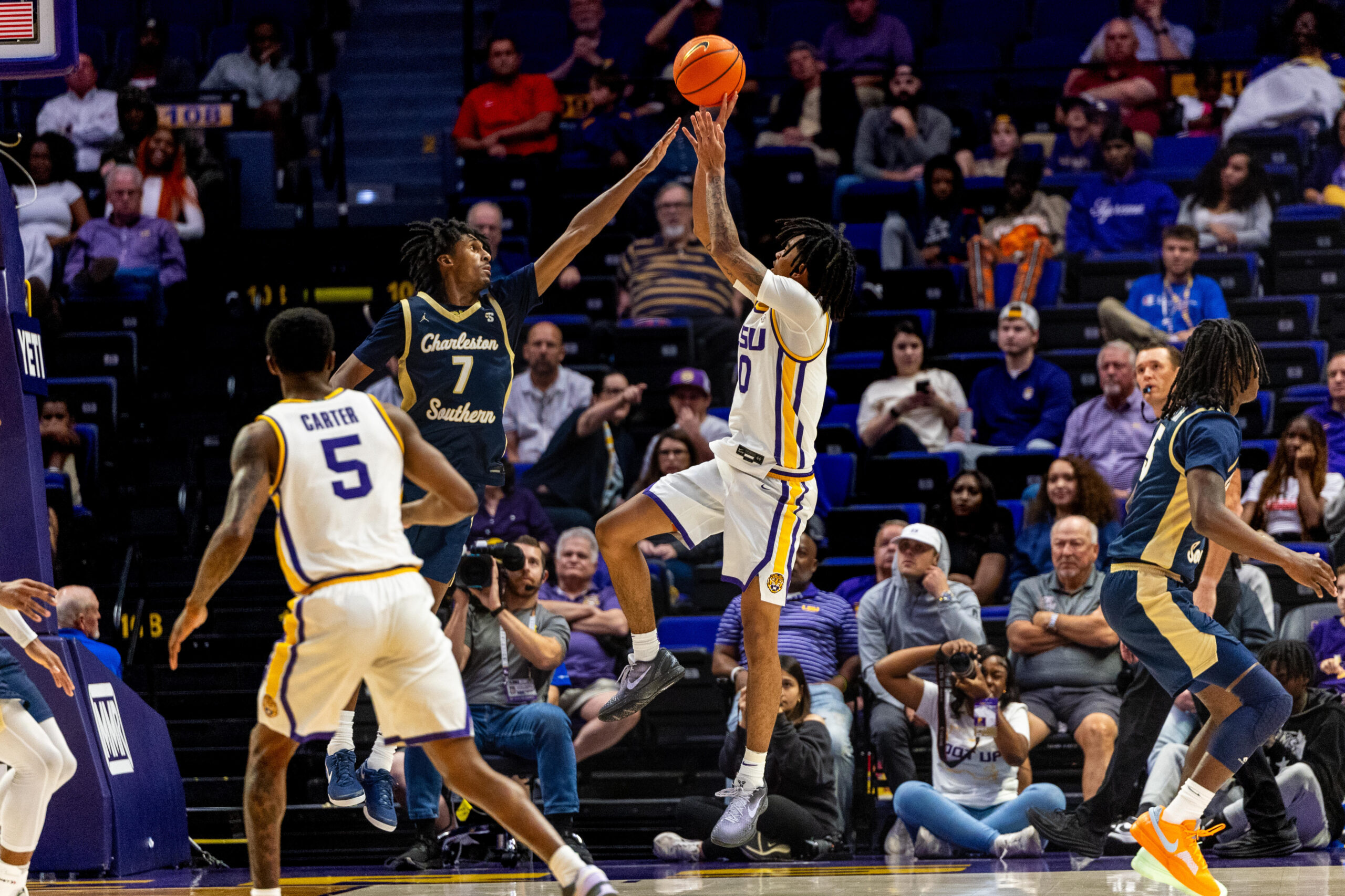 Nov 19, 2024; Baton Rouge, Louisiana, USA;  LSU Tigers forward Daimion Collins (10) shoots a jump shot against Charleston Southern Buccaneers guard Daylen Berry (7) during the second half at Pete Maravich Assembly Center. Mandatory Credit: Stephen Lew-Imagn Images