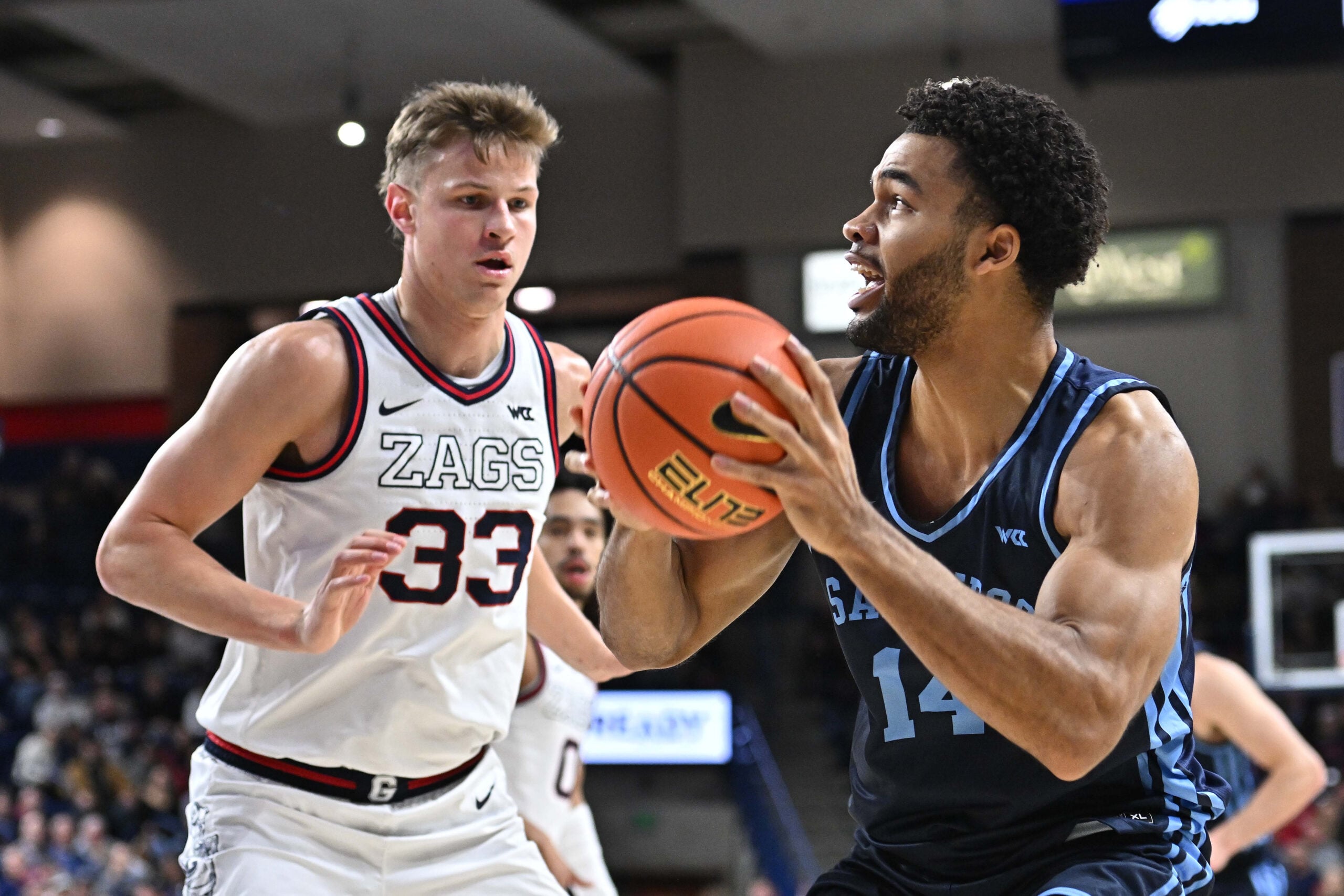 Jan 8, 2025; Spokane, Washington, USA; San Diego Toreros forward Colby Brooks (14) drives against Gonzaga Bulldogs forward Ben Gregg (33) in the second half at McCarthey Athletic Center. Gonzaga Bulldogs won 93-80. Mandatory Credit: James Snook-Imagn Images