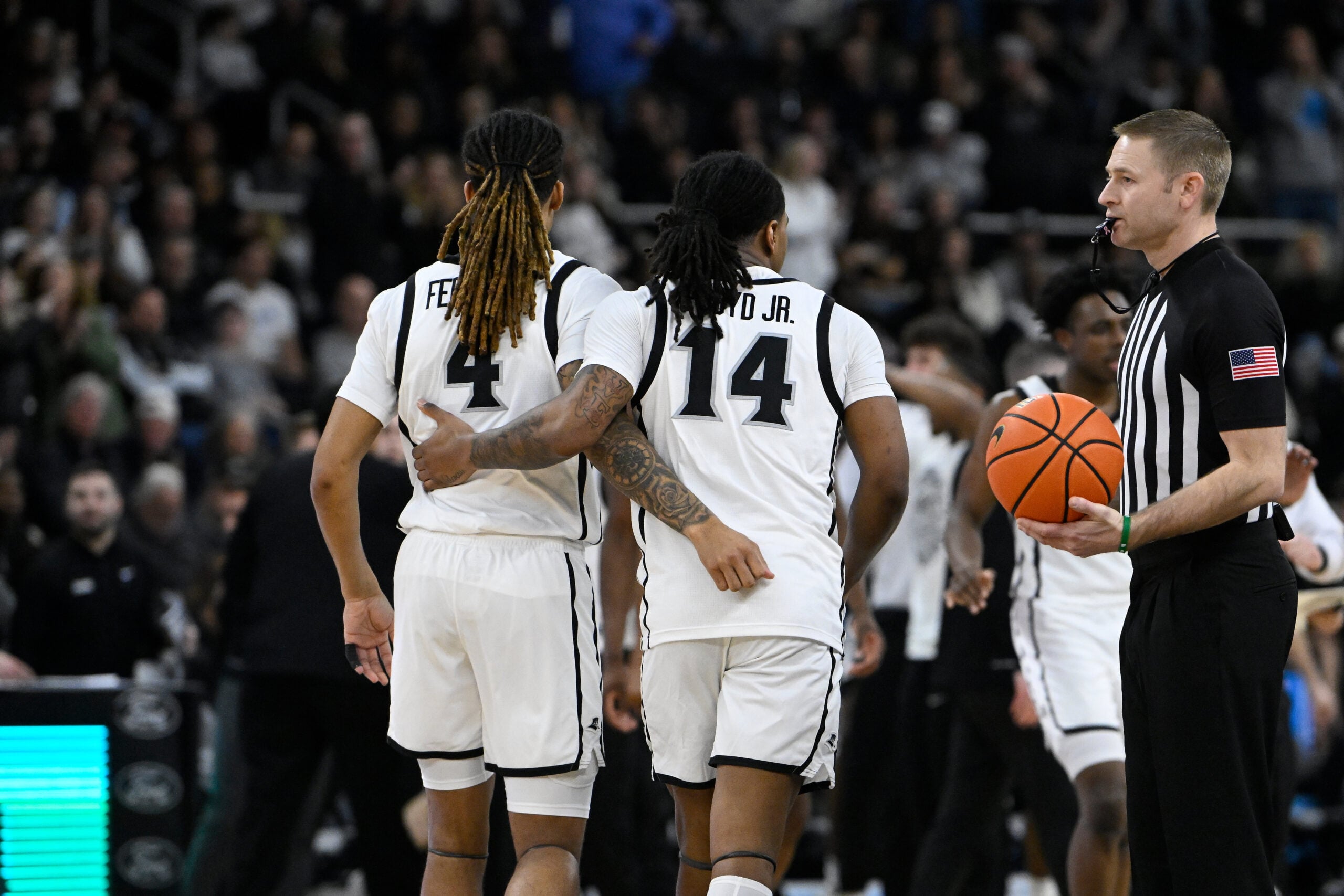 Mar 1, 2025; Providence, Rhode Island, USA; Providence Friars guard Justyn Fernandez (4) and guard Corey Floyd Jr. (14) walk to the bench during the second half against the Connecticut Huskies at Amica Mutual Pavilion. Mandatory Credit: Eric Canha-Imagn Images