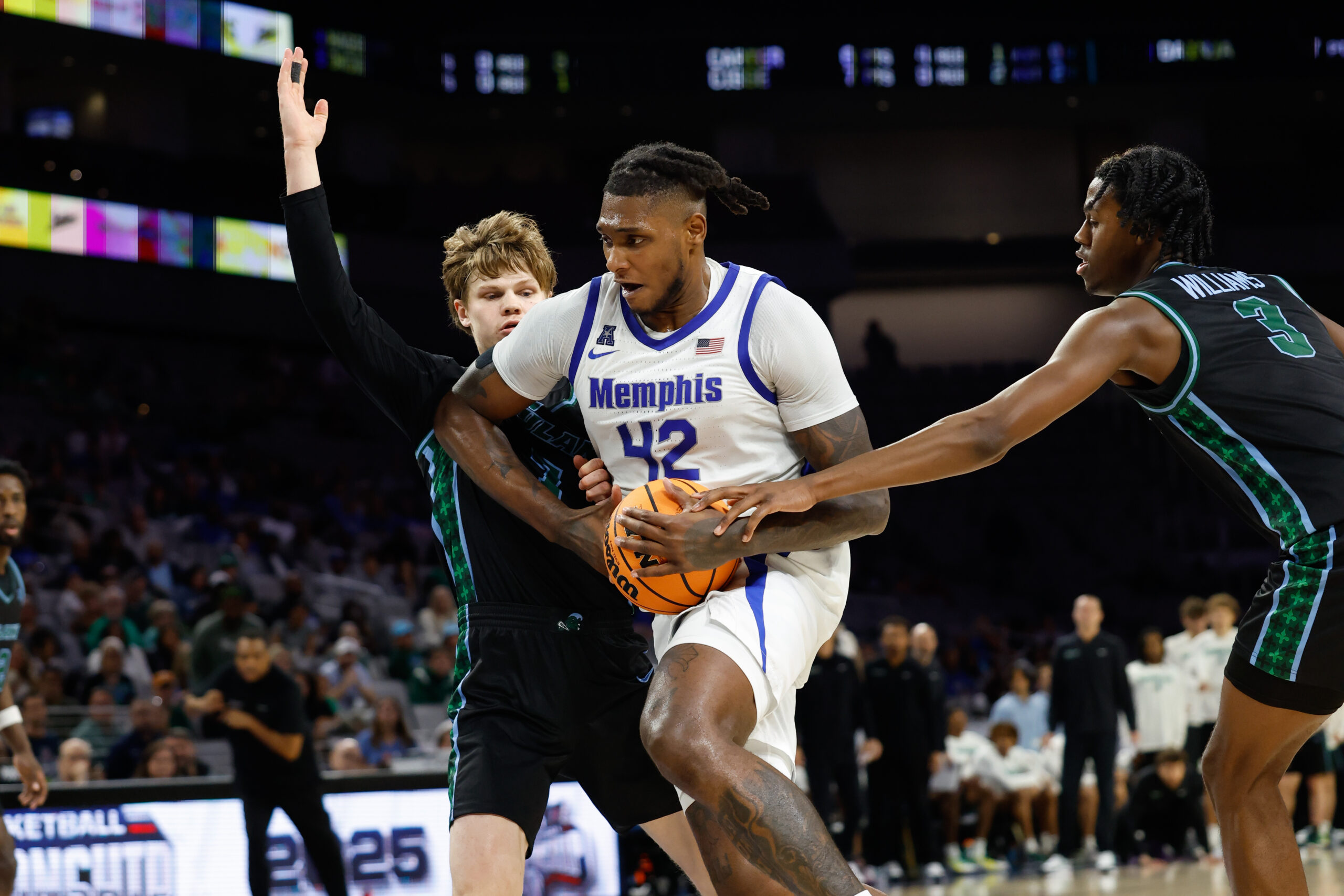 Mar 15, 2025; Fort Worth, TX, USA; Memphis Tigers forward Dain Dainja (42) drives to the basket between Tulane Green Wave guard Rowan Brumbaugh (7) and guard Kam Williams (3) during the second half at Dickies Arena. Mandatory Credit: Chris Jones-Imagn Images