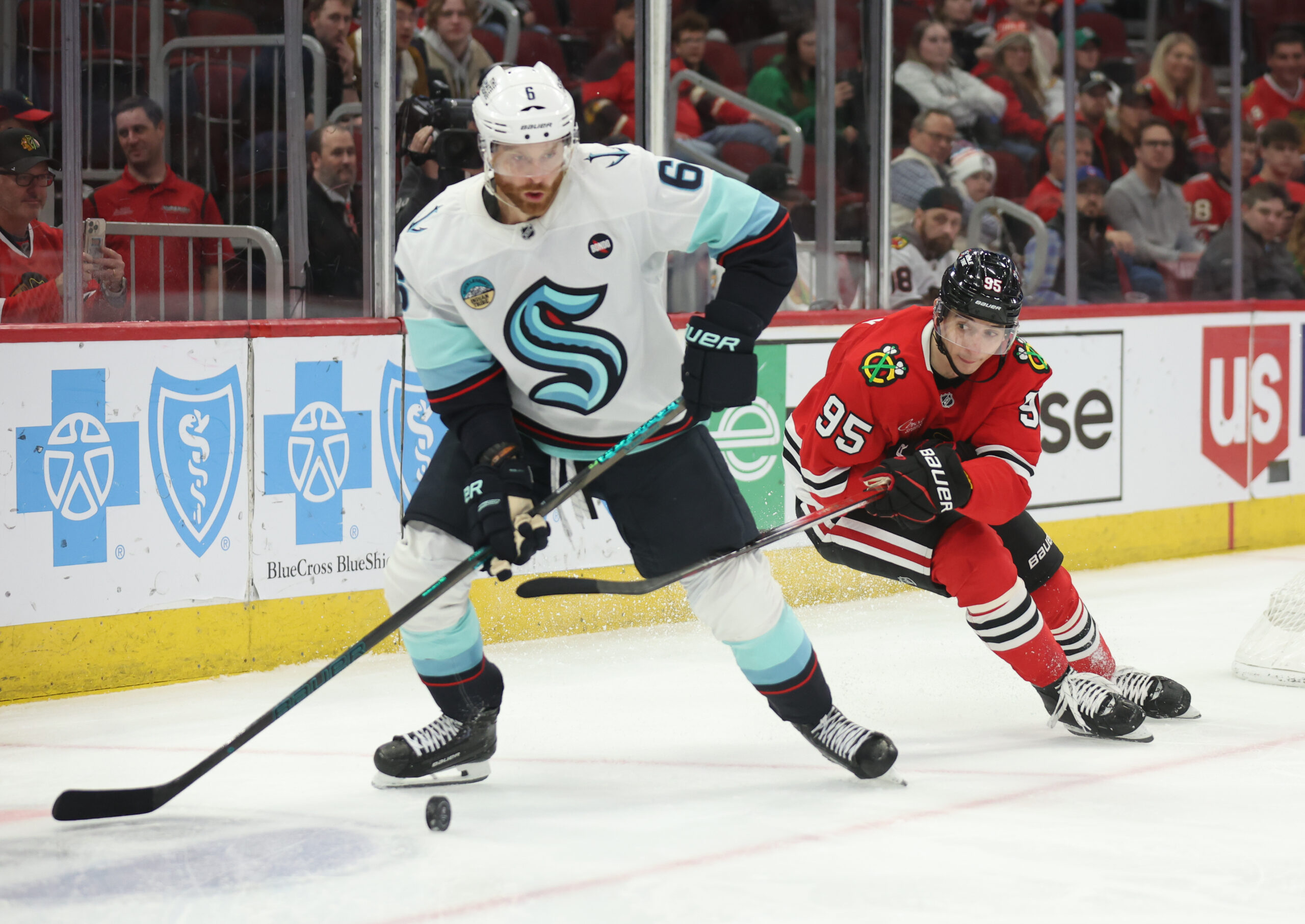 Mar 18, 2025; Chicago, Illinois, USA; Seattle Kraken defenseman Adam Larsson (6) and Chicago Blackhawks right wing Ilya Mikheyev (95) battle for control of the puck during the third period at United Center. Mandatory Credit: Talia Sprague-Imagn Images