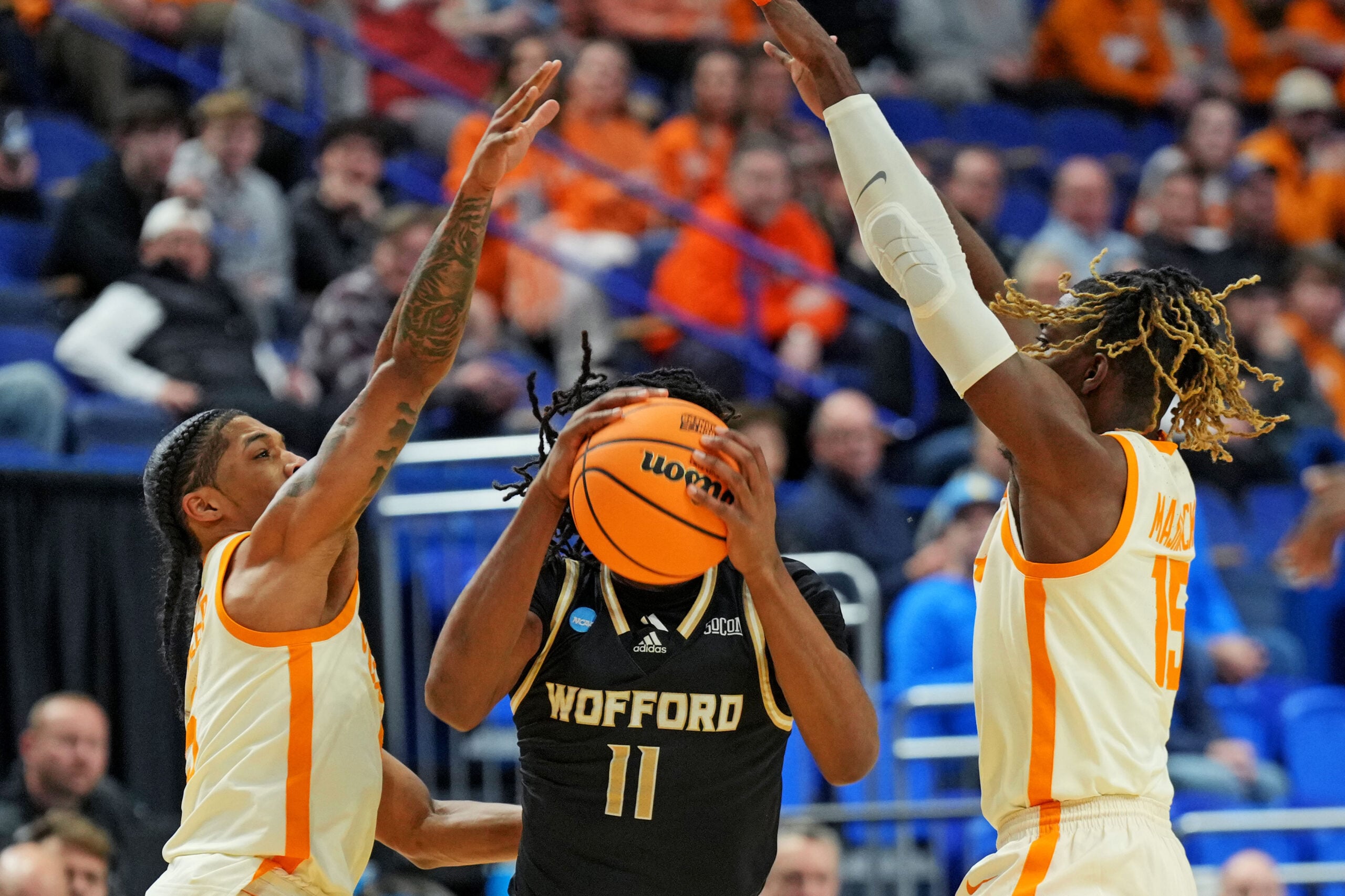 Mar 20, 2025; Lexington, KY, USA; Wofford Terriers guard Kahmare Holmes (11) handles the ball against Tennessee Volunteers guard Zakai Zeigler (5) and guard Jahmai Mashack (15) during the first half in the first round of the NCAA Tournament at Rupp Arena. Mandatory Credit: Aaron Doster-Imagn Images