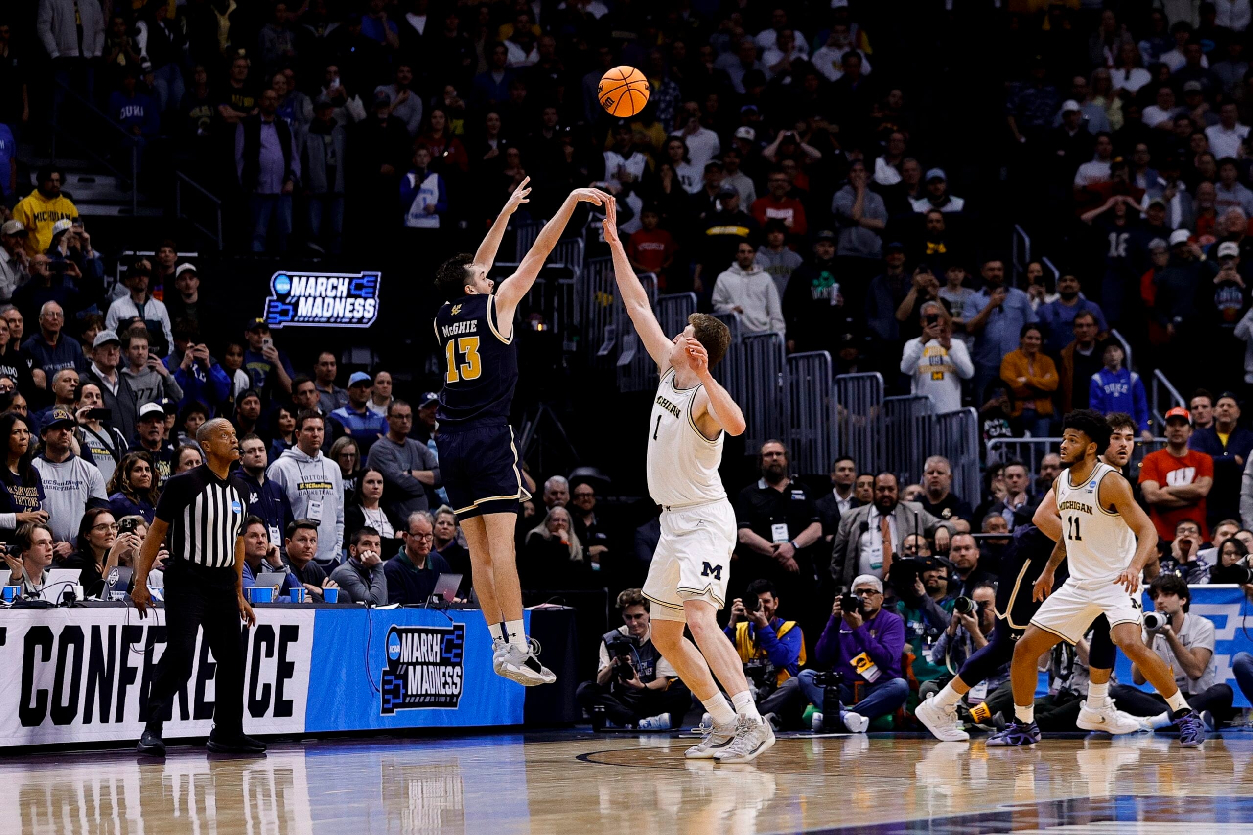 March 20, 2025; Denver, CO, USA; UC San Diego Tritons guard Tyler McGhie (13) shoots over Michigan Wolverines center Danny Wolf (1) during the second half at Ball Arena. Mandatory Credit: Isaiah J. Downing-Imagn Images