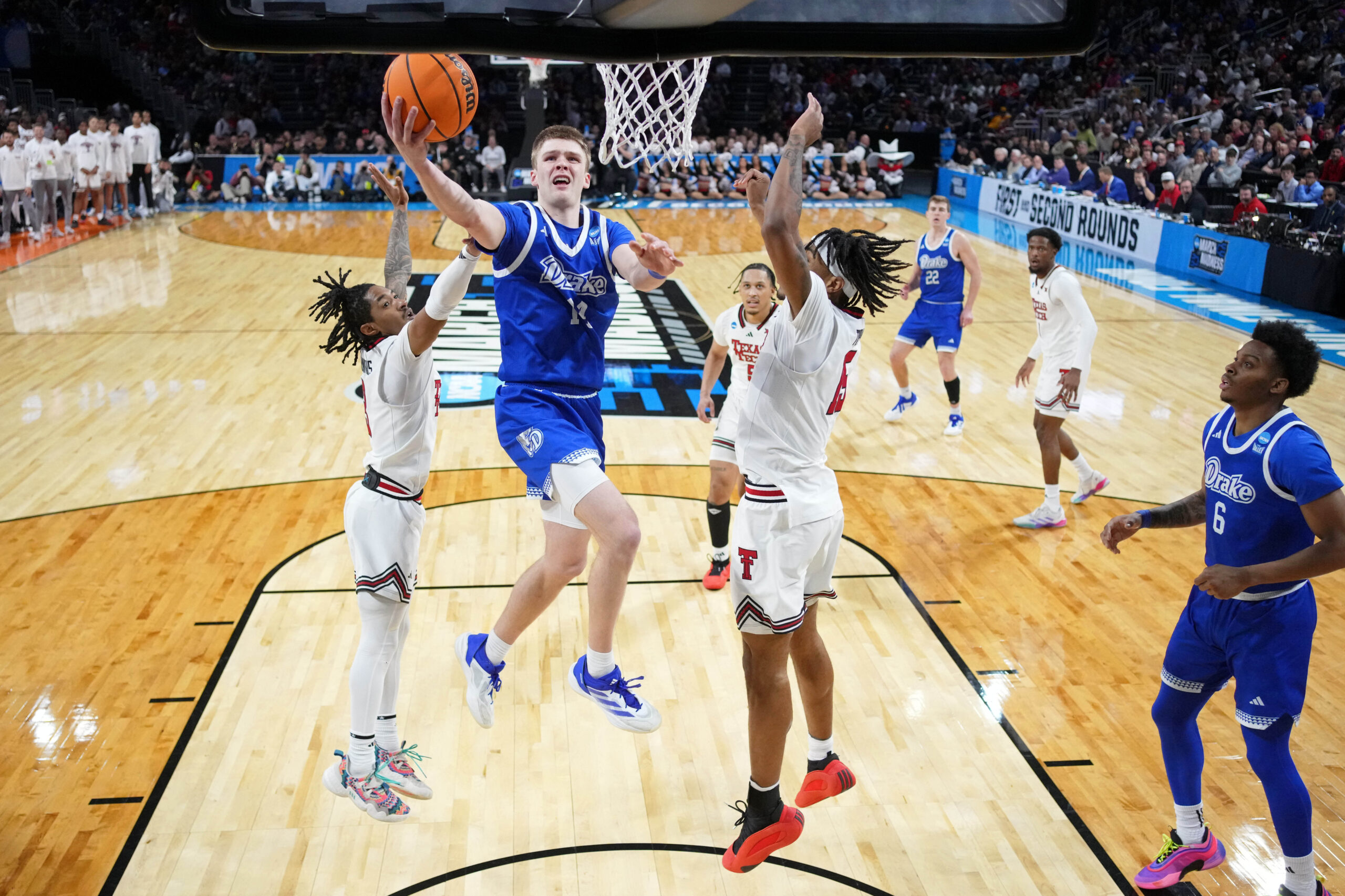 Mar 22, 2025; Wichita, KS, USA; Drake Bulldogs guard Bennett Stirtz (14) shoots the ball against Texas Tech Red Raiders guard Elijah Hawkins (3) and forward JT Toppin (15) during the second half at Intrust Bank Arena. Mandatory Credit: Kirby Lee-Imagn Images