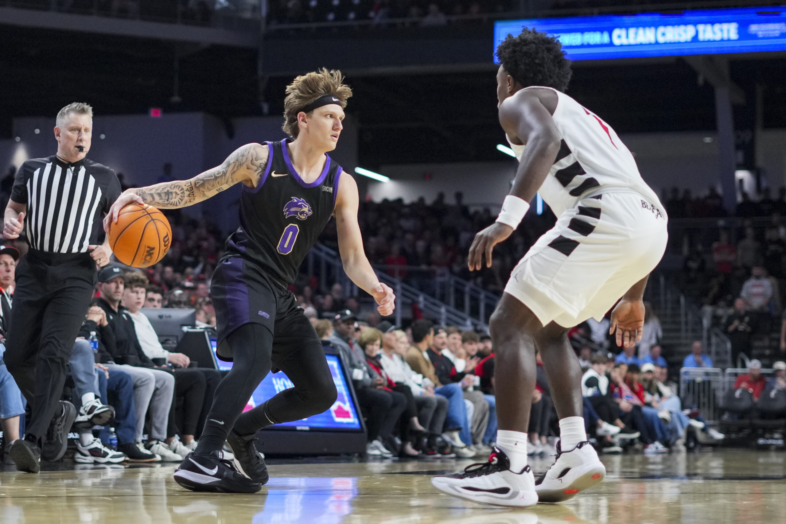 Nov 3, 2025; Cincinnati, Ohio, USA;  Western Carolina Catamounts guard Cord Stansberry (0) dribbles the ball against Cincinnati Bearcats guard Keyshuan Tillery (7) in the second half at Fifth Third Arena. Mandatory Credit: Aaron Doster-Imagn Images