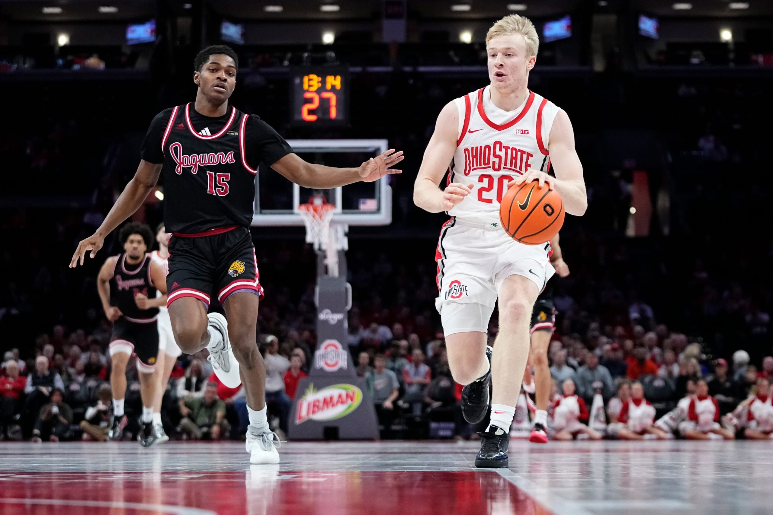 Ohio State Buckeyes forward Colin White (20) dribbles ahead of IU Indy Jaguars guard Matt Compas (15) during the NCAA men's basketball game at Value City Arena in Columbus on Nov. 3, 2025. Ohio State won the season opener 118-102.
