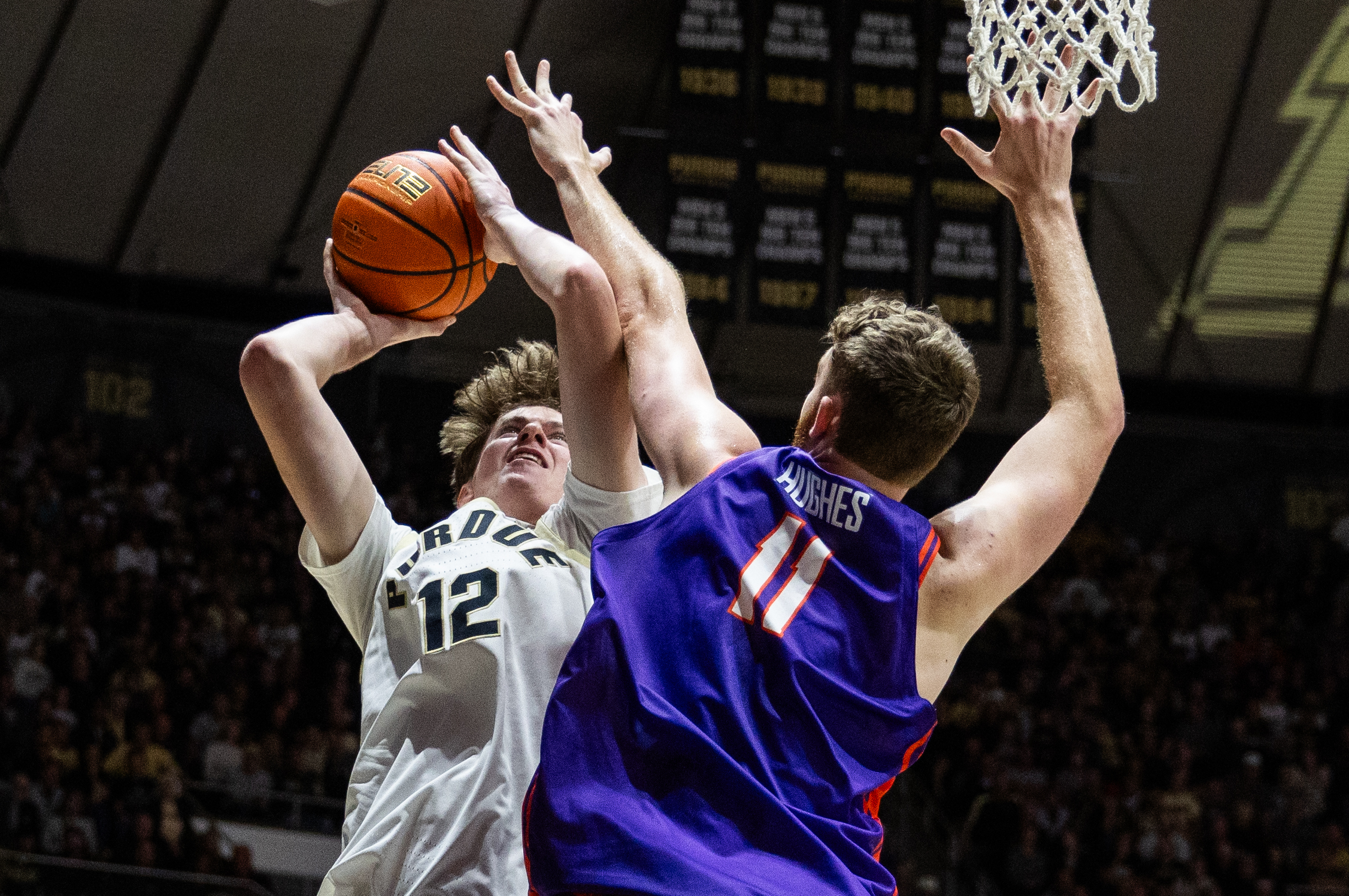 Nov 4, 2025; West Lafayette, Indiana, USA; Purdue Boilermakers center Daniel Jacobsen (12) shoots the ball while  Evansville Purple Aces forward Joshua Hughes (11) defends in the second half  at Mackey Arena. Mandatory Credit: Trevor Ruszkowski-Imagn Images