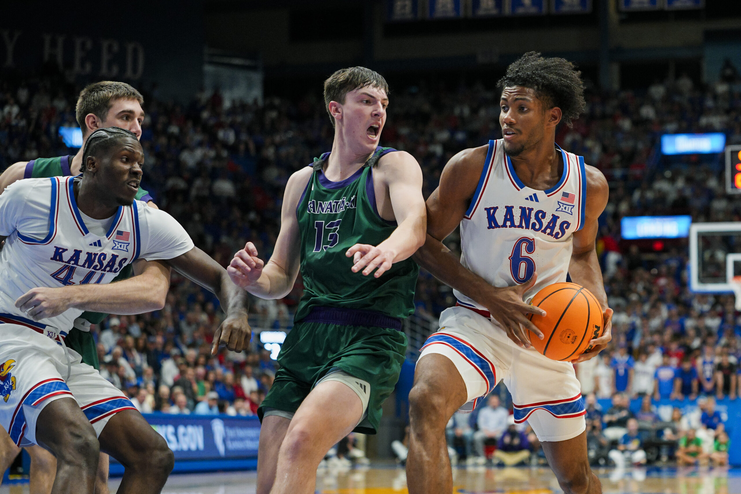 Nov 3, 2025; Lawrence, Kansas, USA; Kansas Jayhawks forward Samis Calderon (6) drives against Green Bay Phoenix forward Marcus Hall (13) during the second half at Allen Fieldhouse. Mandatory Credit: Jay Biggerstaff-Imagn Images