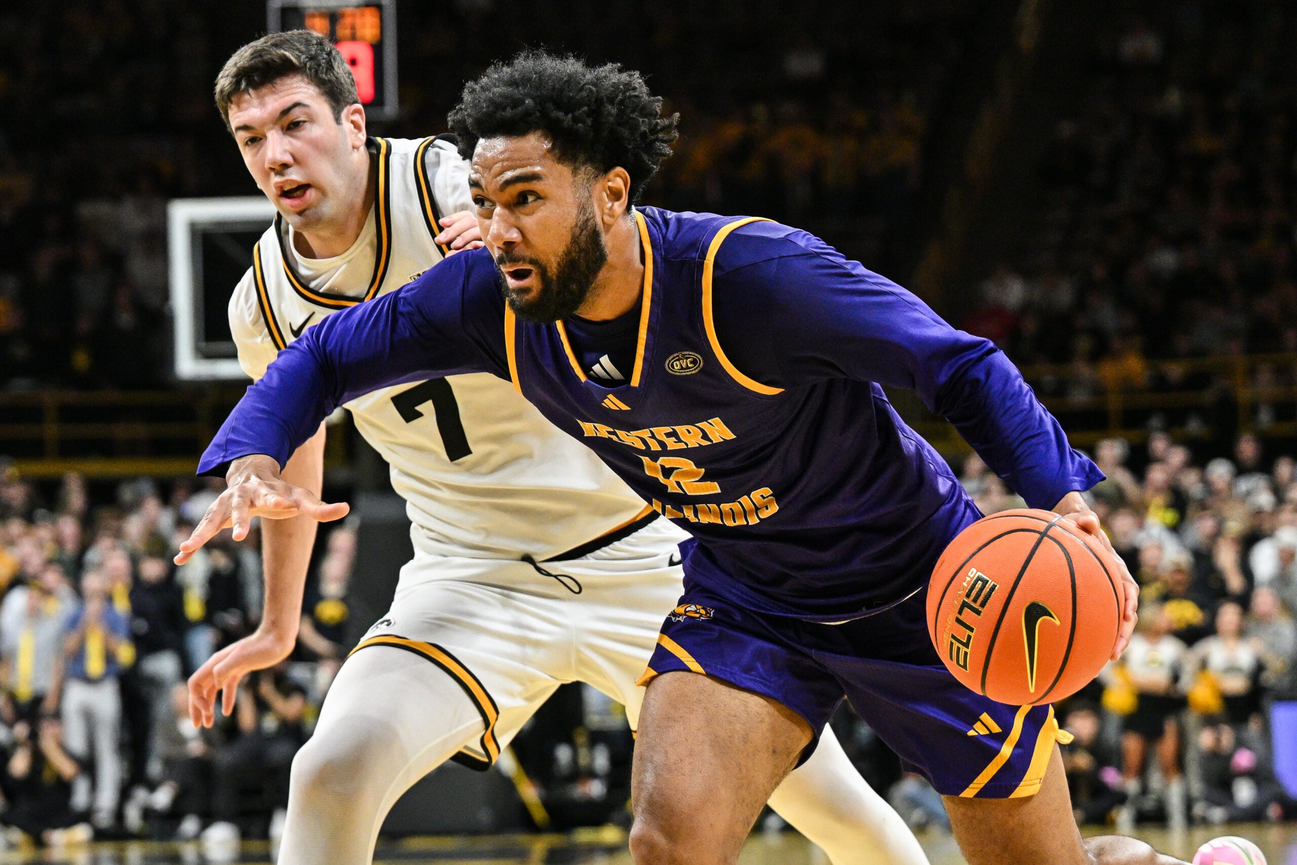 Nov 7, 2025; Iowa City, Iowa, USA; Western Illinois Leathernecks forward Isaiah Griffin (12) goes to the basket as Iowa Hawkeyes forward Alvaro Folgueiras (7) defends during the first half at Carver-Hawkeye Arena. Mandatory Credit: Jeffrey Becker-Imagn Images