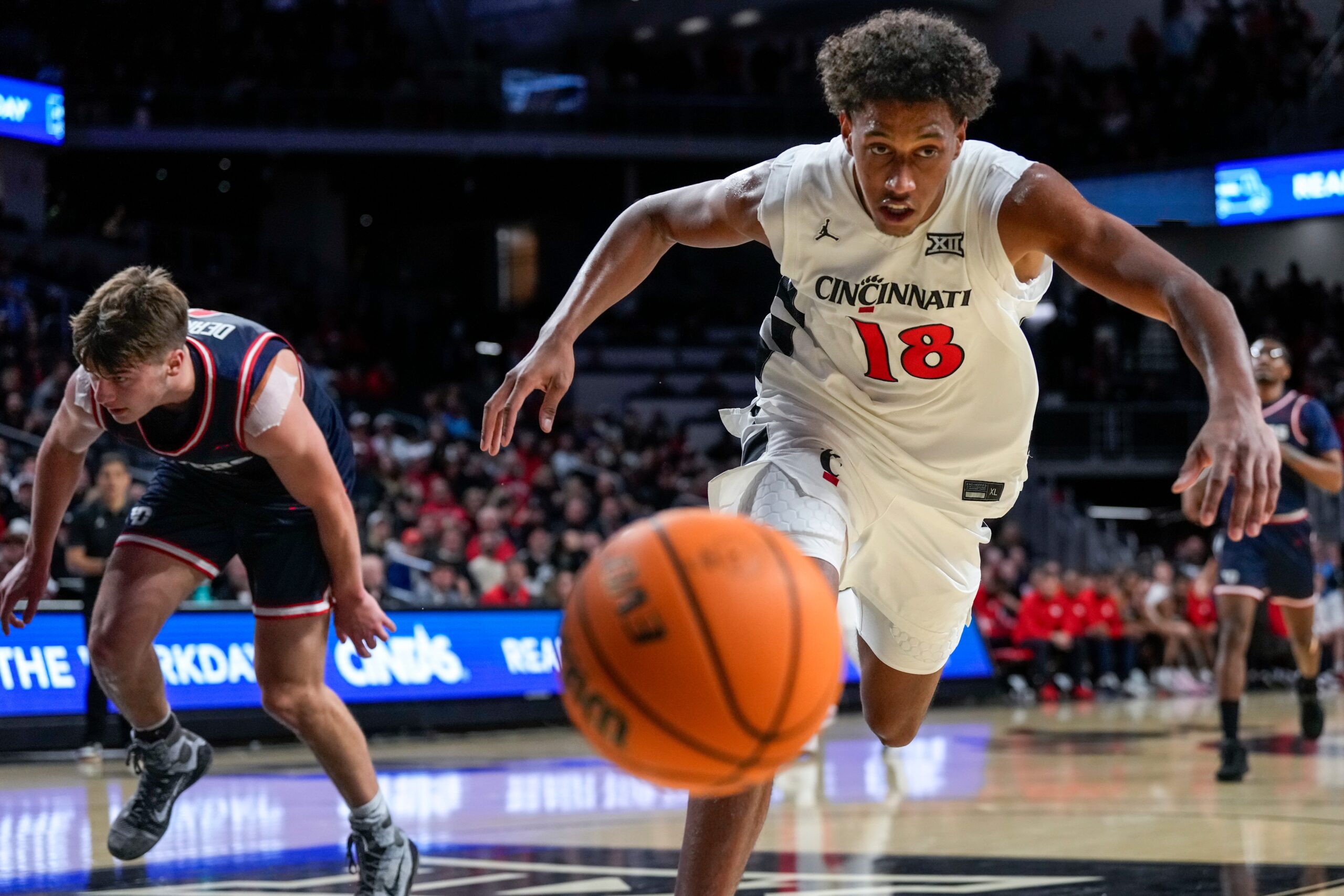 Cincinnati Bearcats forward Baba Miller (18) chases a loose ball out of bounds in the second half of the NCAA Men’s Basketball game between the Cincinnati Bearcats and the Dayton Flyers at Fifth Third Arena in Cincinnati on Tuesday, Nov. 11, 2025. The Bearcats won 74-62.