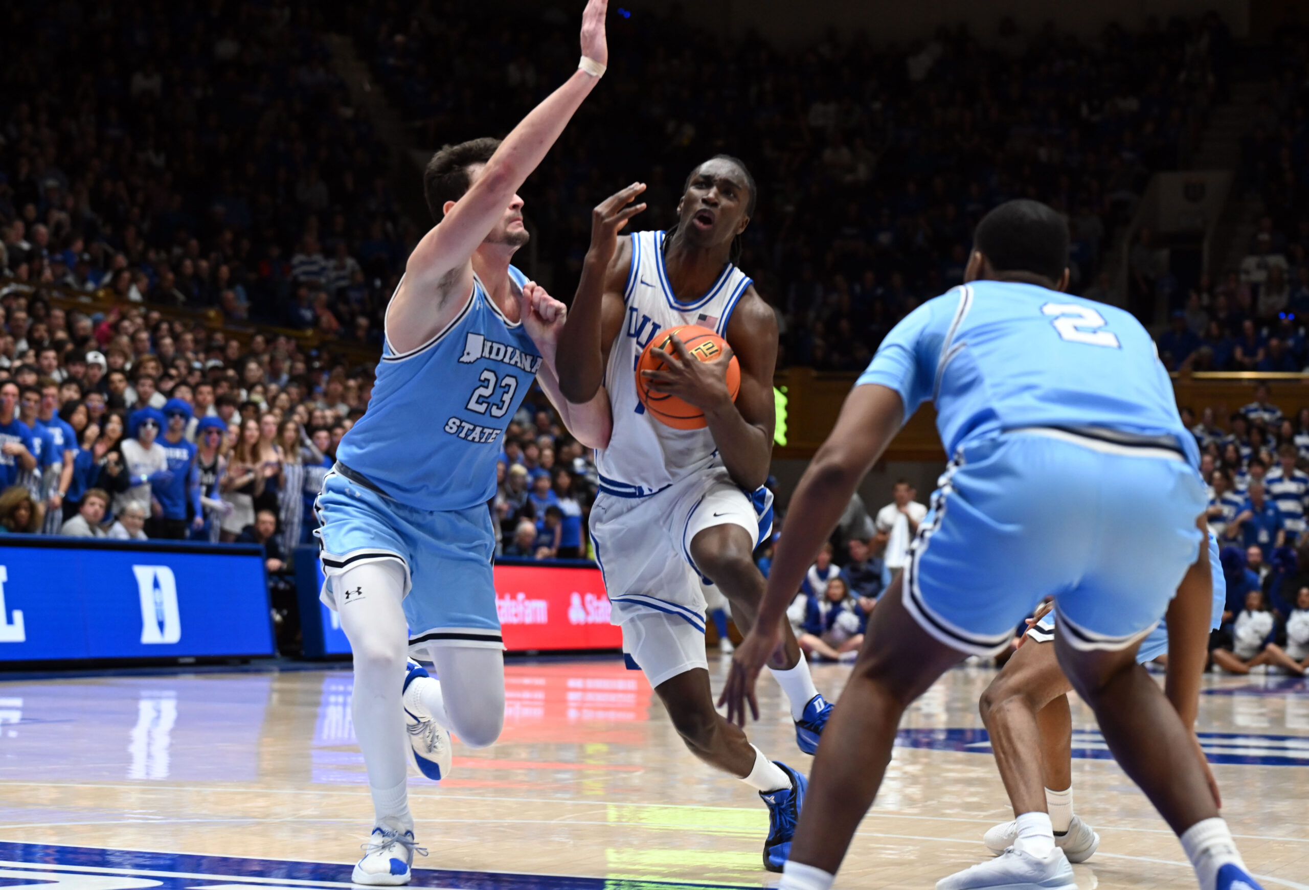 Nov 14, 2025; Durham, North Carolina, USA; Duke Blue Devils forward Dame Sarr (7) drives to the basket as Indiana State Sycamores forward Ian Scott (23) defends during the second half at Cameron Indoor Stadium. Mandatory Credit: Rob Kinnan-Imagn Images