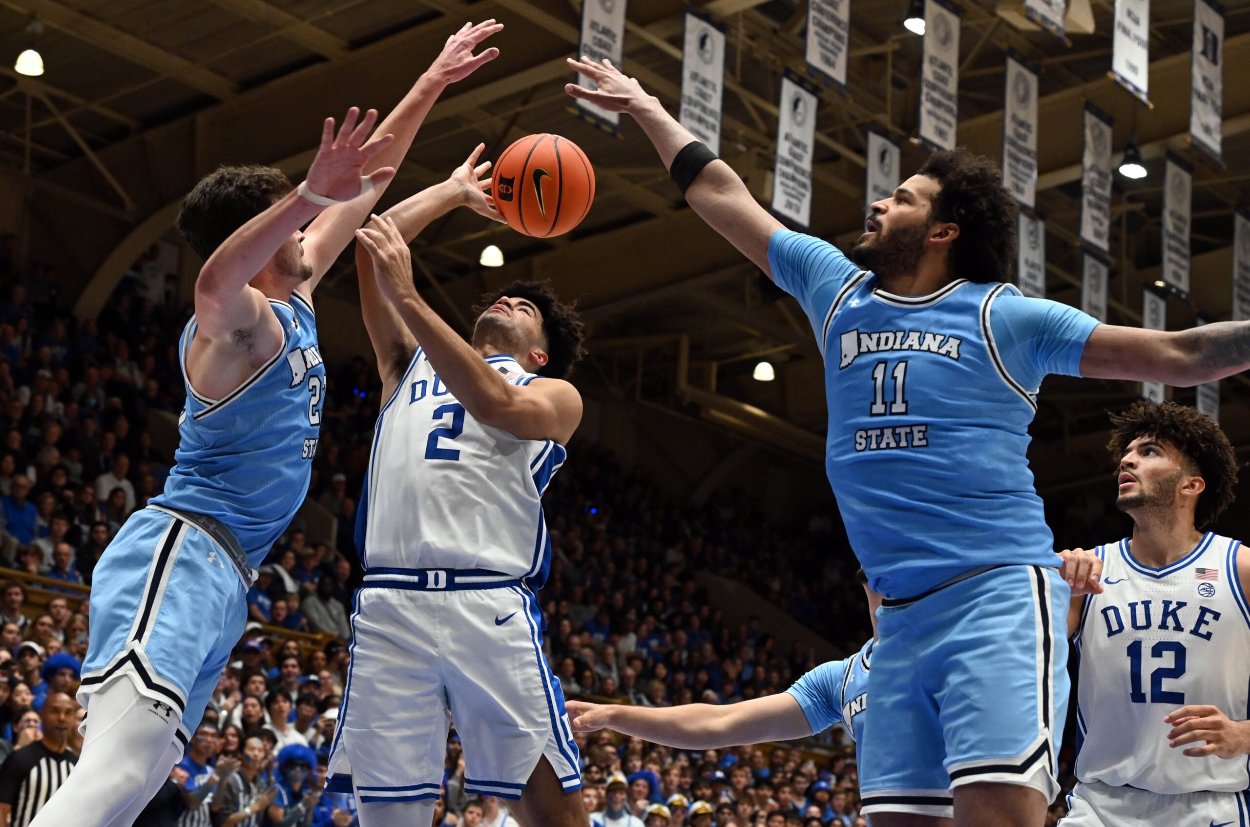 Nov 14, 2025; Durham, North Carolina, USA; Duke Blue Devils guard Cayden Boozer (2) throws a pass in front of Indiana State Sycamores forward Ian Scott (23) and center Markus Harding (11) during the second half at Cameron Indoor Stadium. Mandatory Credit: Rob Kinnan-Imagn Images