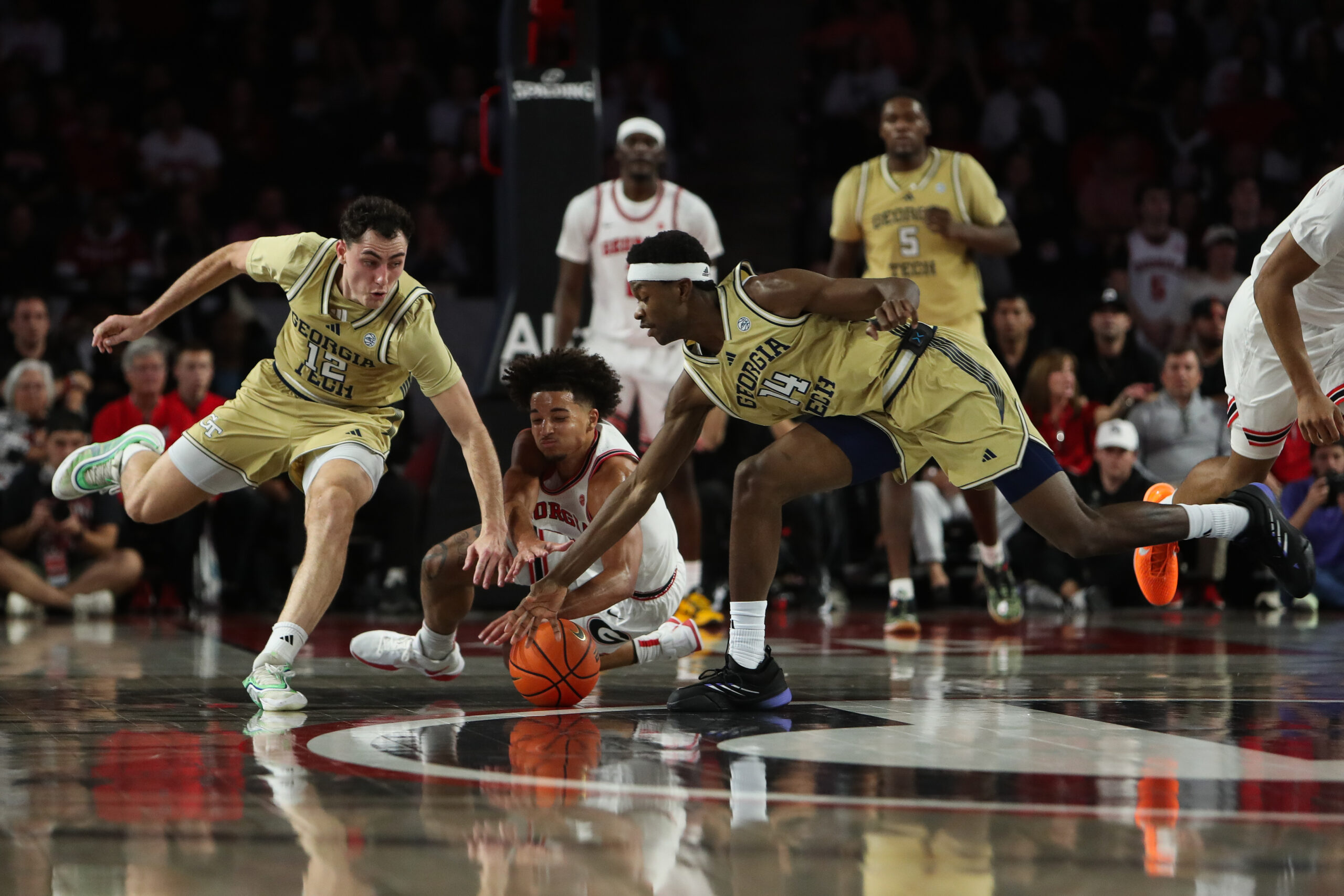 Nov 14, 2025; Athens, Georgia, USA; Georgia Bulldogs guard Jordan Ross (3) reaches for the ball against Georgia Tech Yellow Jackets guard Kam Craft (12) and Georgia Tech Yellow Jackets forward Kowacie Reeves Jr. (14) during the second half at Stegeman Coliseum. Mandatory Credit: Mady Mertens-Imagn Images
