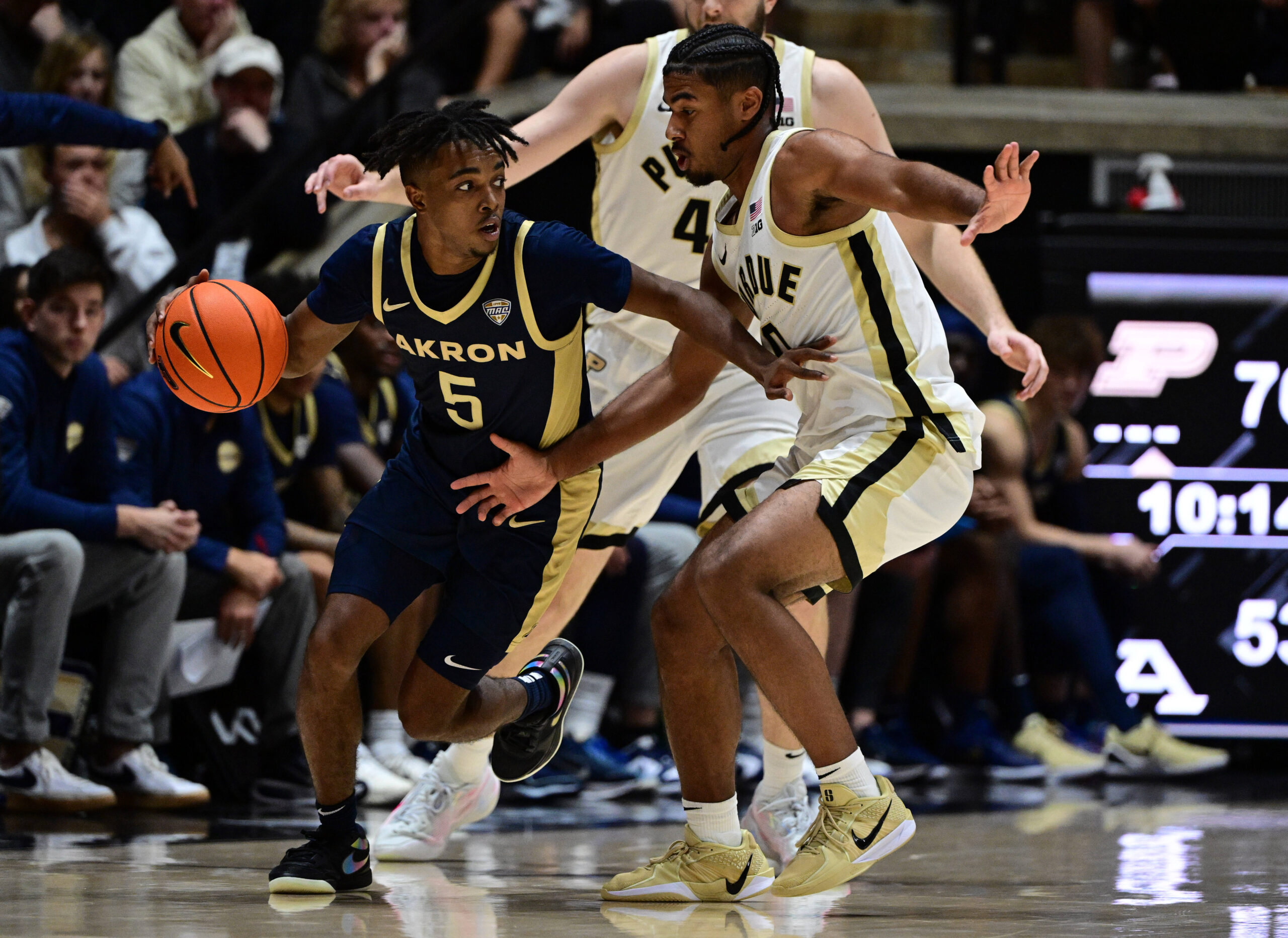 Nov 16, 2025; West Lafayette, Indiana, USA;  Akron Zips guard Tavari Johnson (5) drives past Purdue Boilermakers guard C.J. Cox (0) during the second half at Mackey Arena. Mandatory Credit: Marc Lebryk-Imagn Images